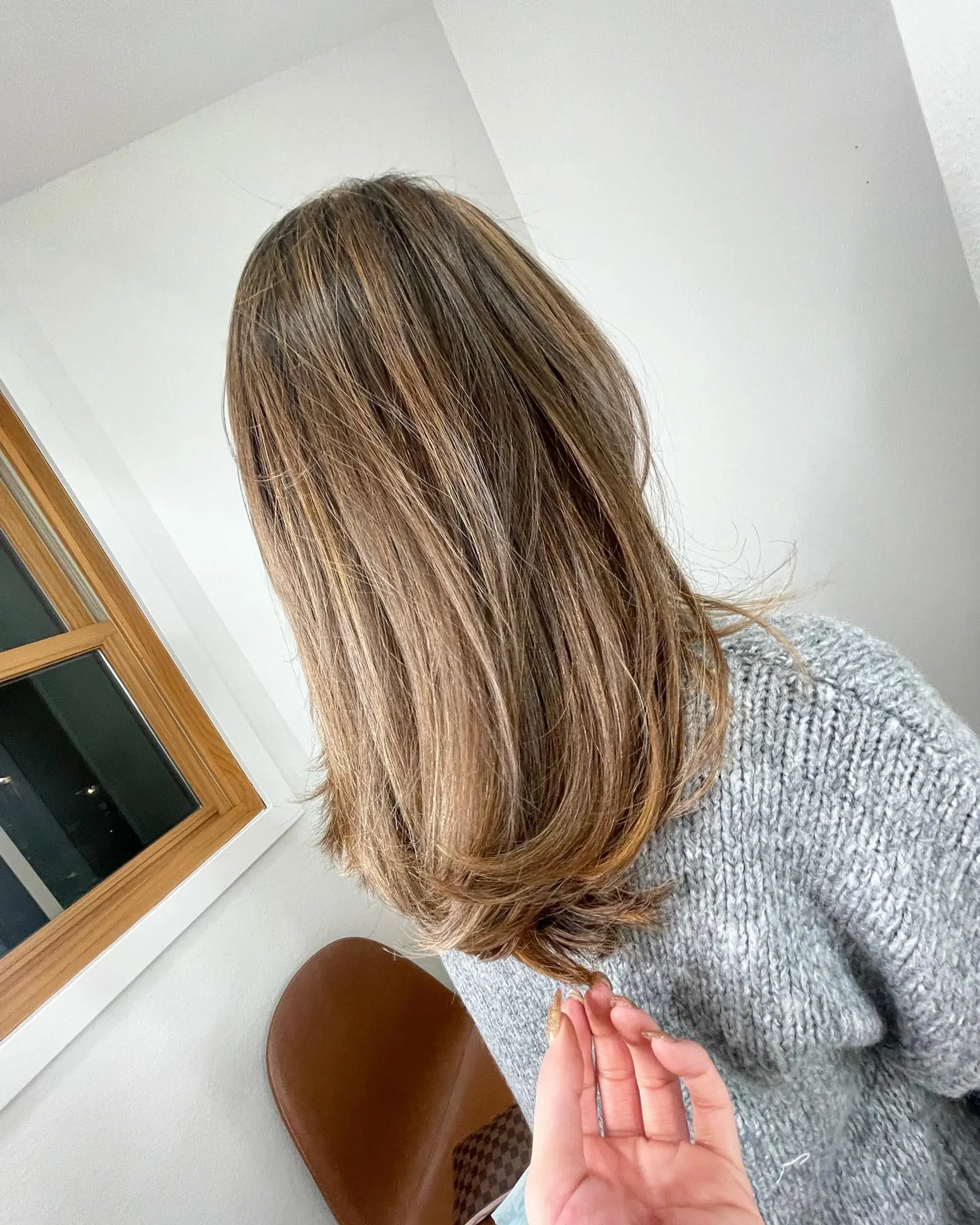 Medium-length layered hair styled smooth with softly beveled ends, featuring warm golden caramel balayage dimension. 1