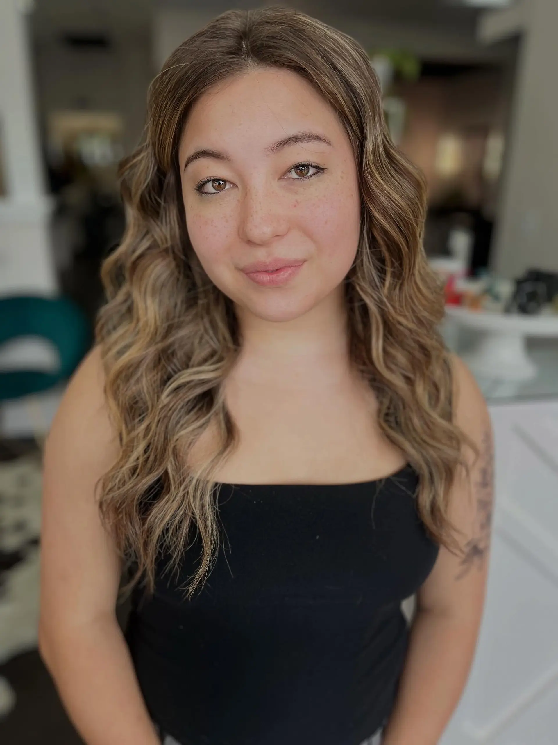 Long hair featuring a seamless blonde balayage blend styled in loose, voluminous cascading waves. 1