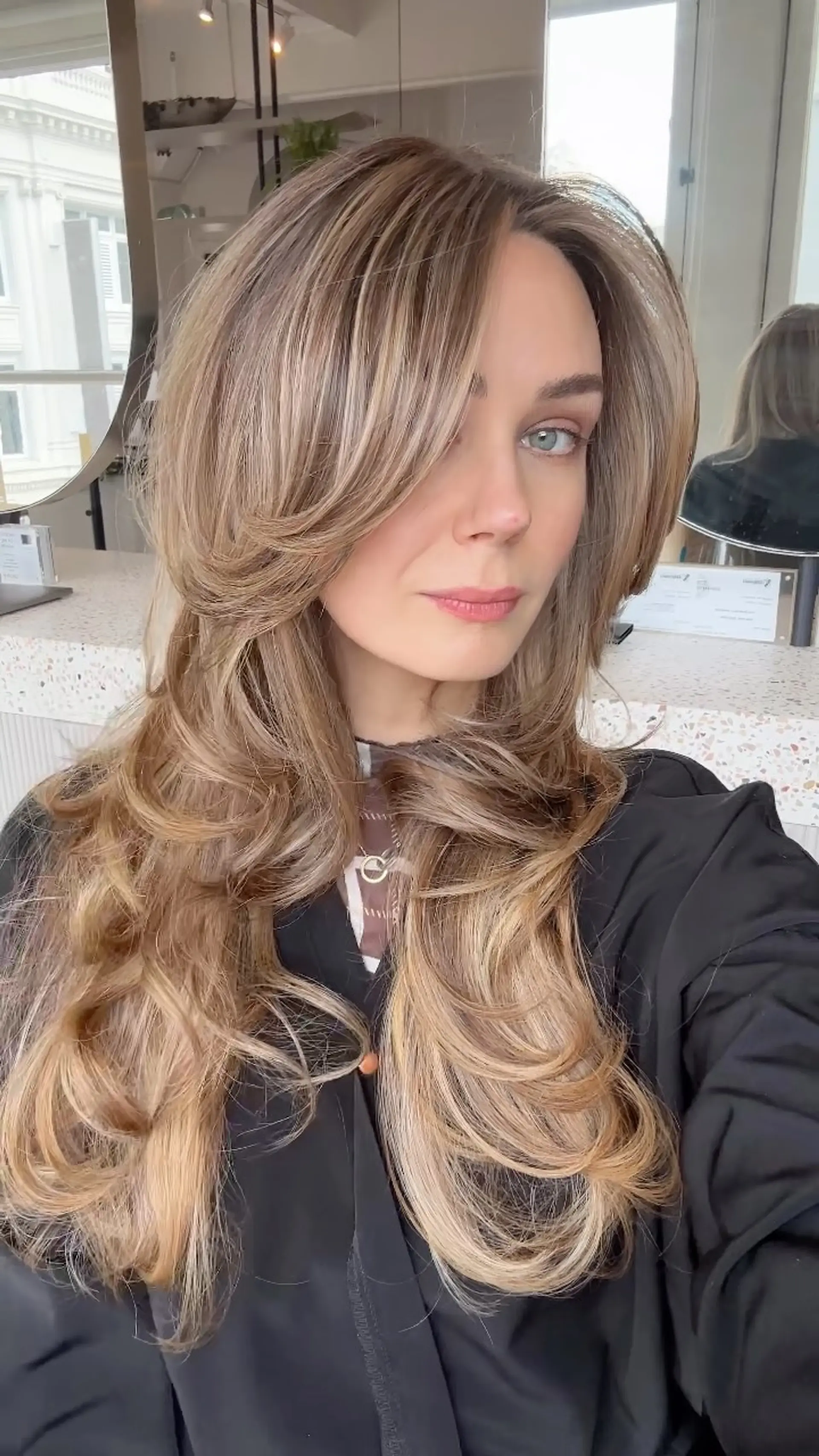 Voluminous long layered blowout with swooping face-framing curtain layers and soft curled ends. 1