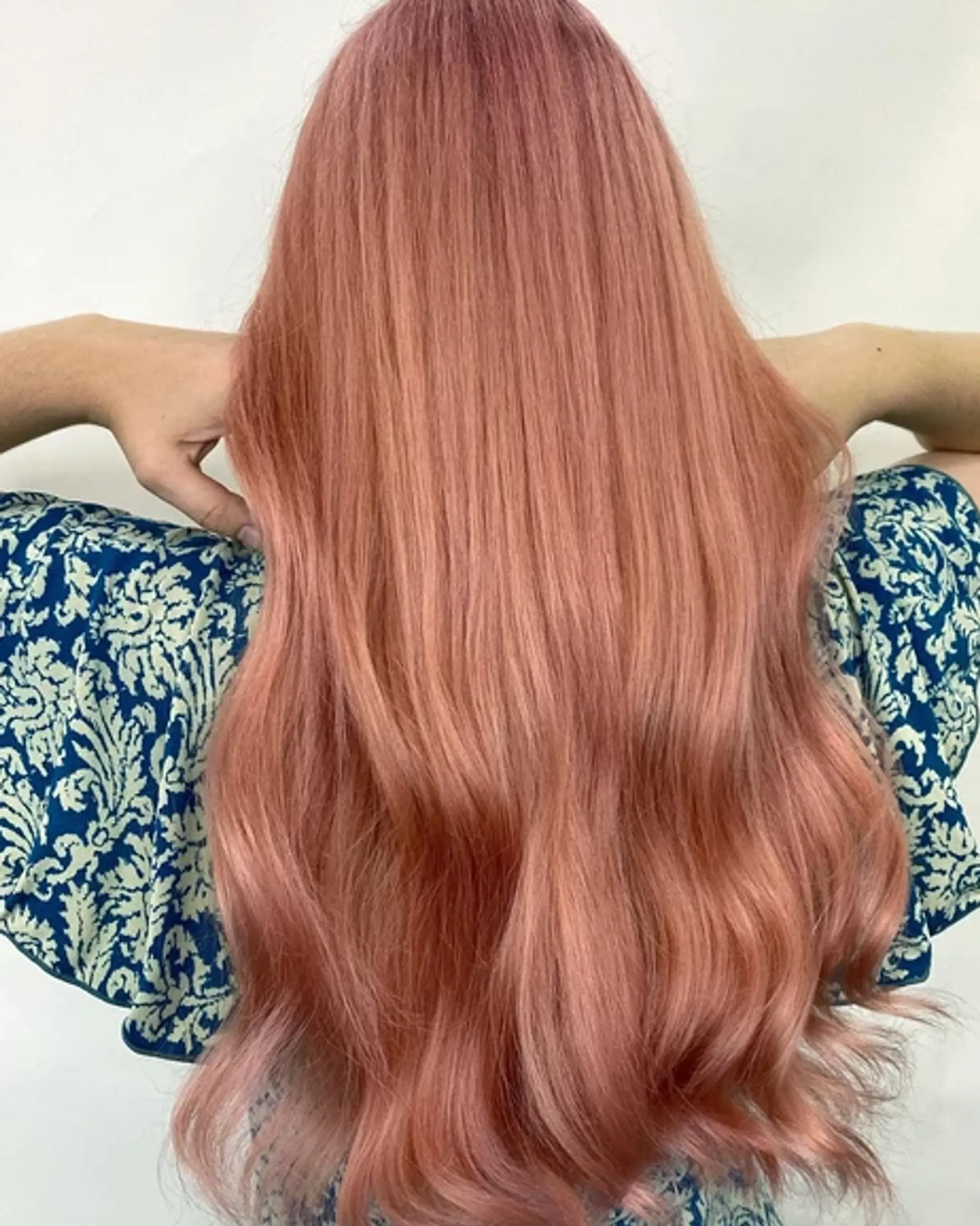 Voluminous, very long, rose gold hair with loose, elegant waves radiating a healthy shine and soft texture.