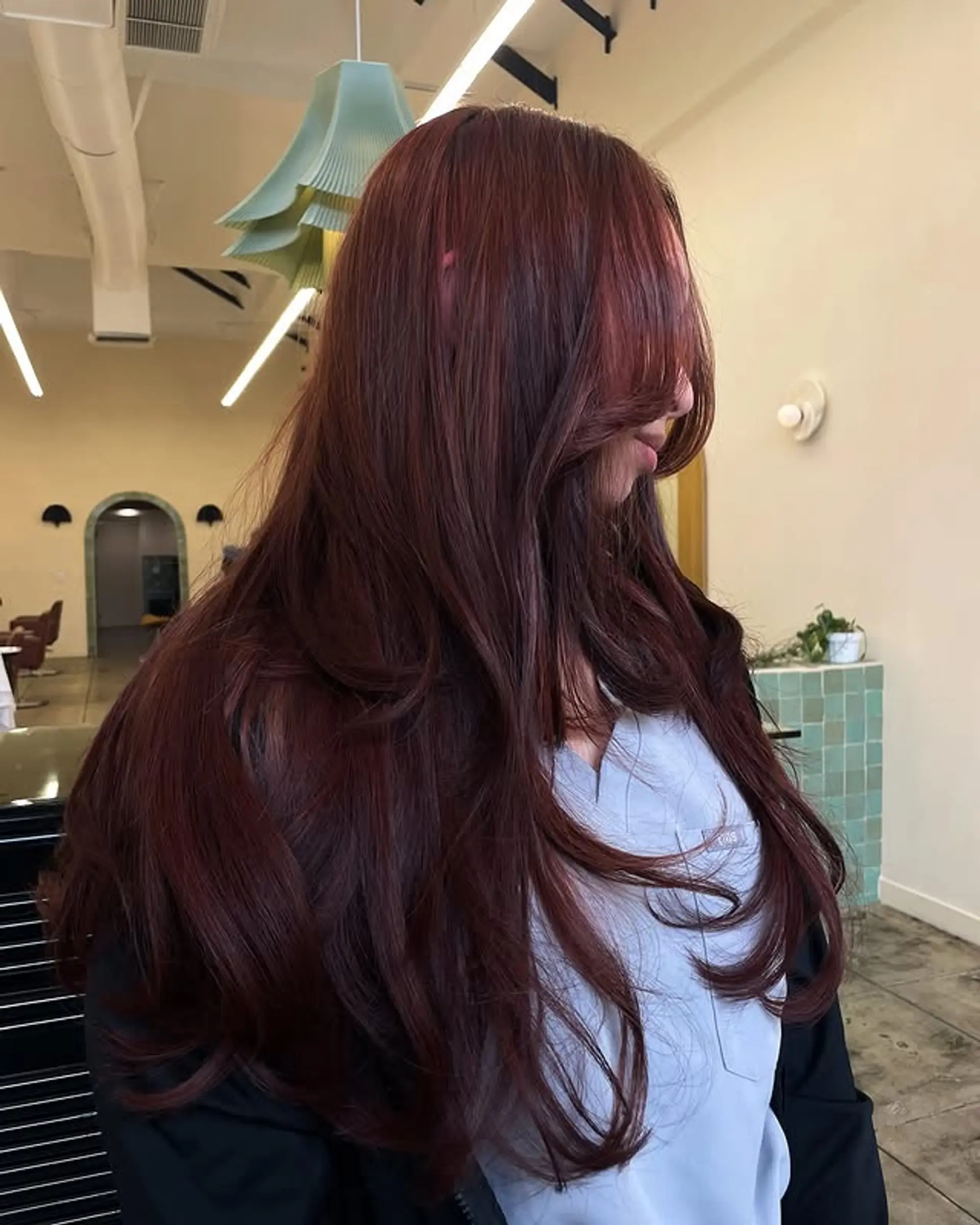 This long hairstyle features face framing layers and trendy curtain bangs. 1