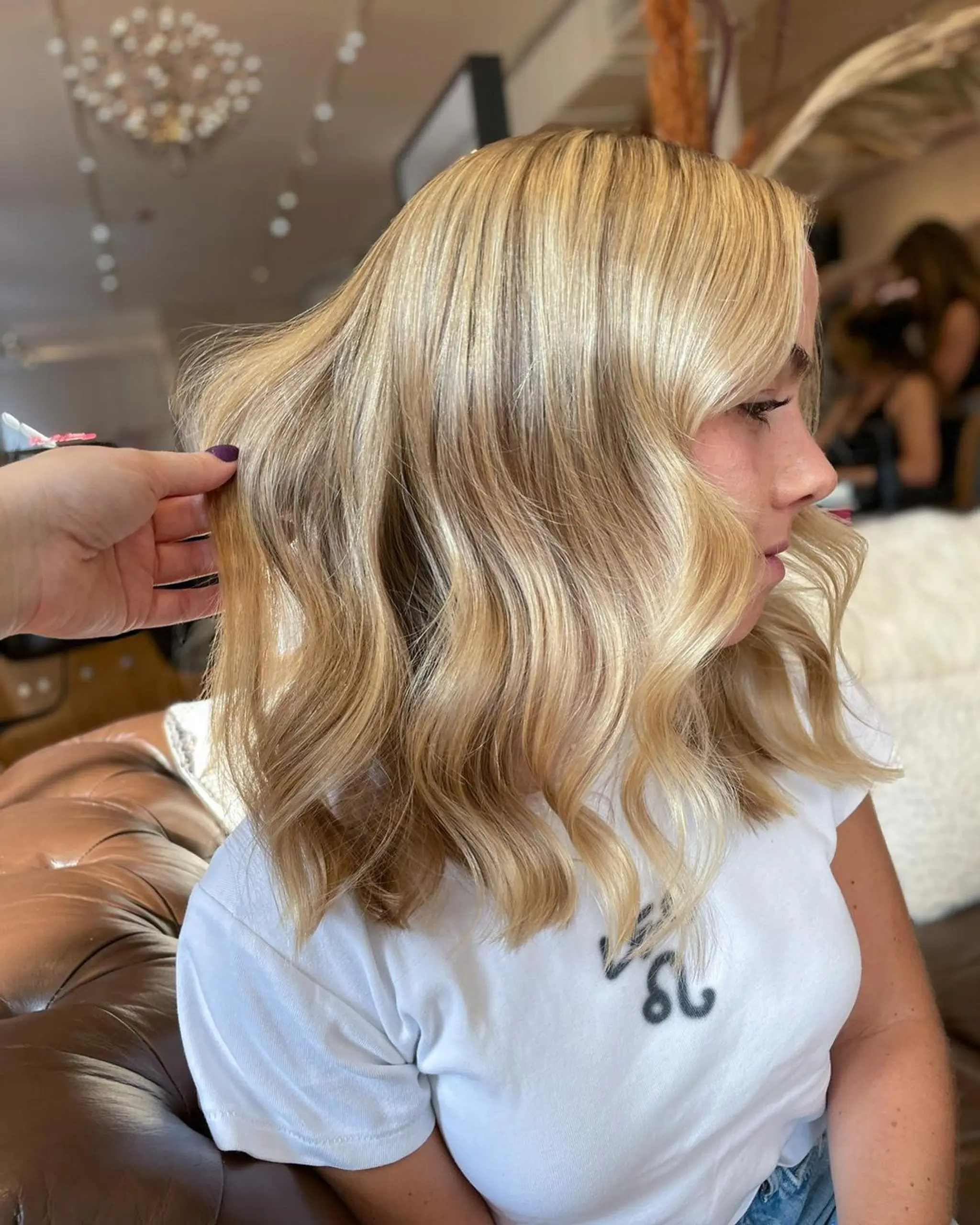 Medium-length, wavy blonde hair with soft, natural waves and a brilliant golden hue.