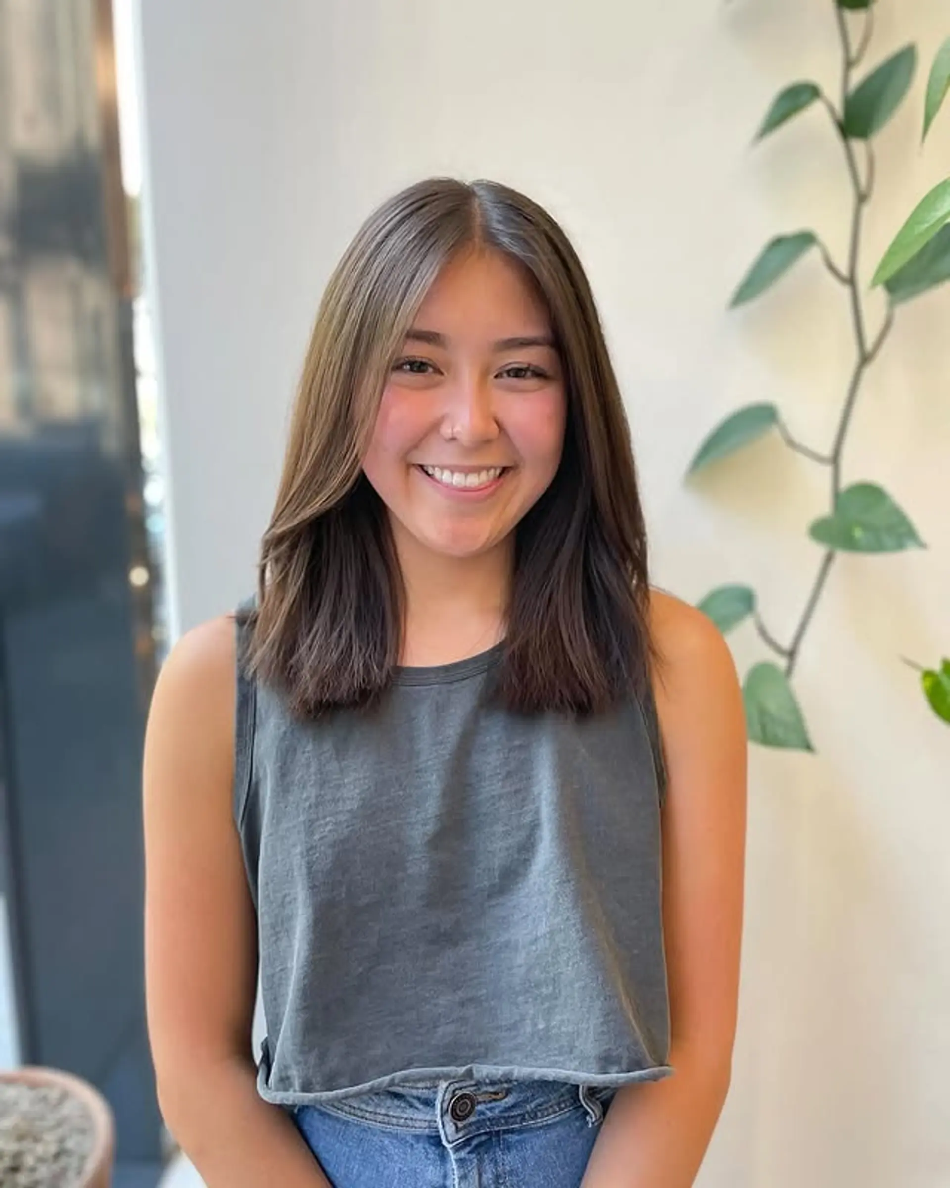 A layered haircut with face-framing layers and a center part. 1