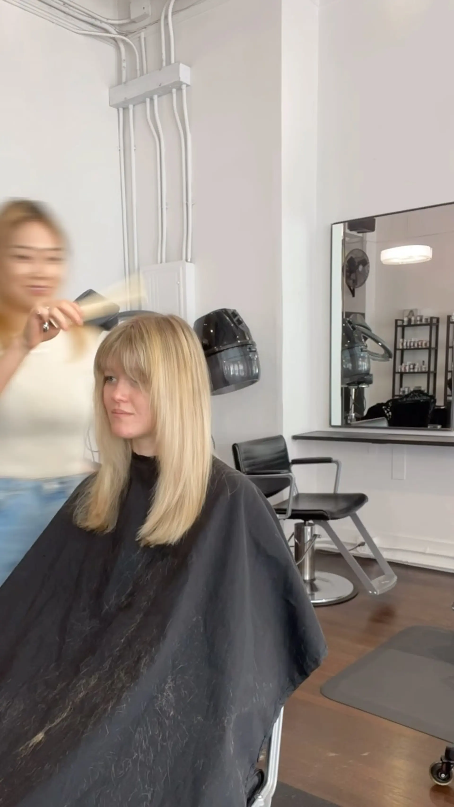 A sleek, straight blonde haircut styled with full, eyebrow-length bangs and smooth ends. 1