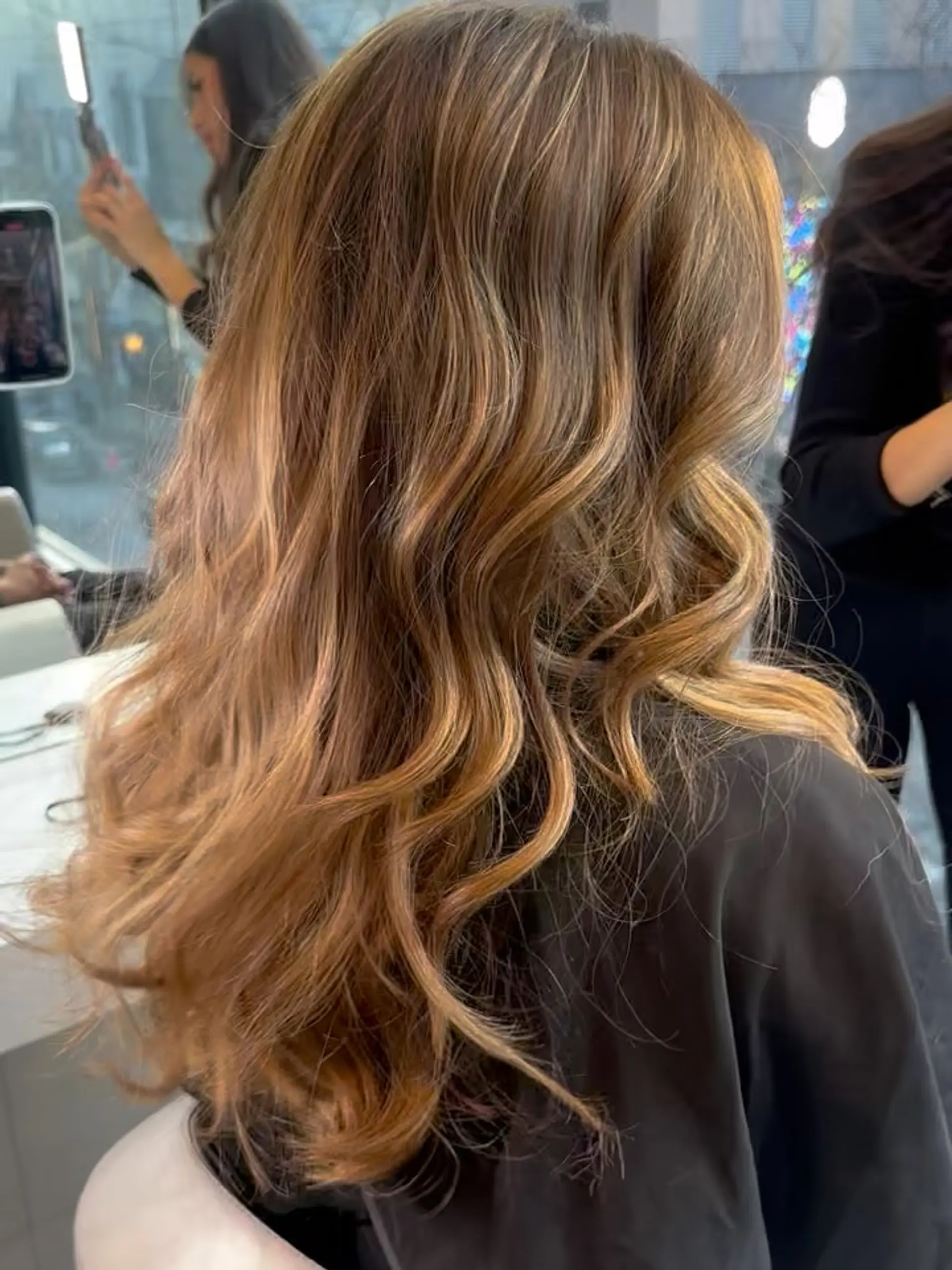 Long dimensional caramel and golden brown balayage styled into flowing, soft curls. 1