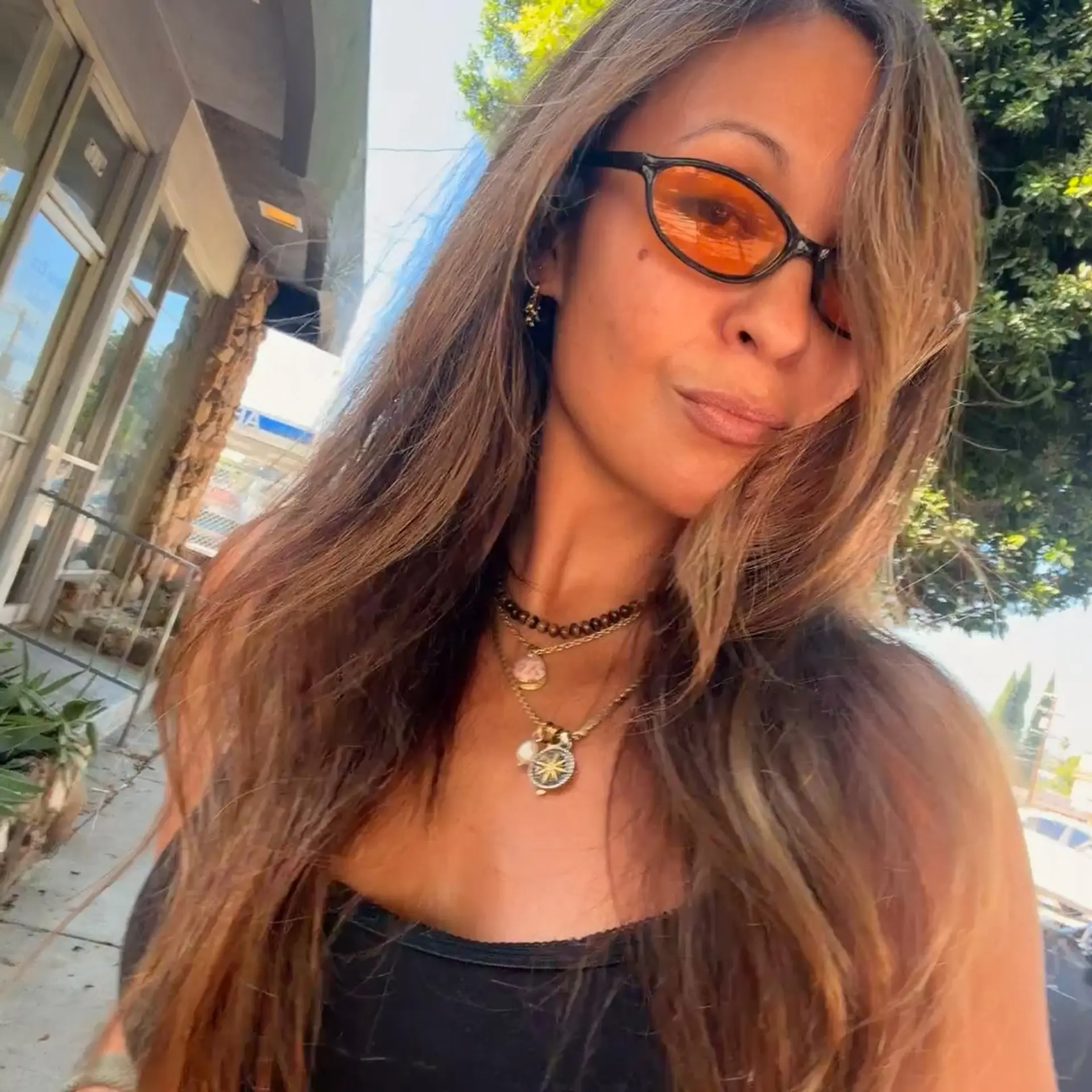 Long dimensional light brown hair with soft caramel highlights, styled into a tousled, voluminous blowout with side-swept face-framing layers. 1