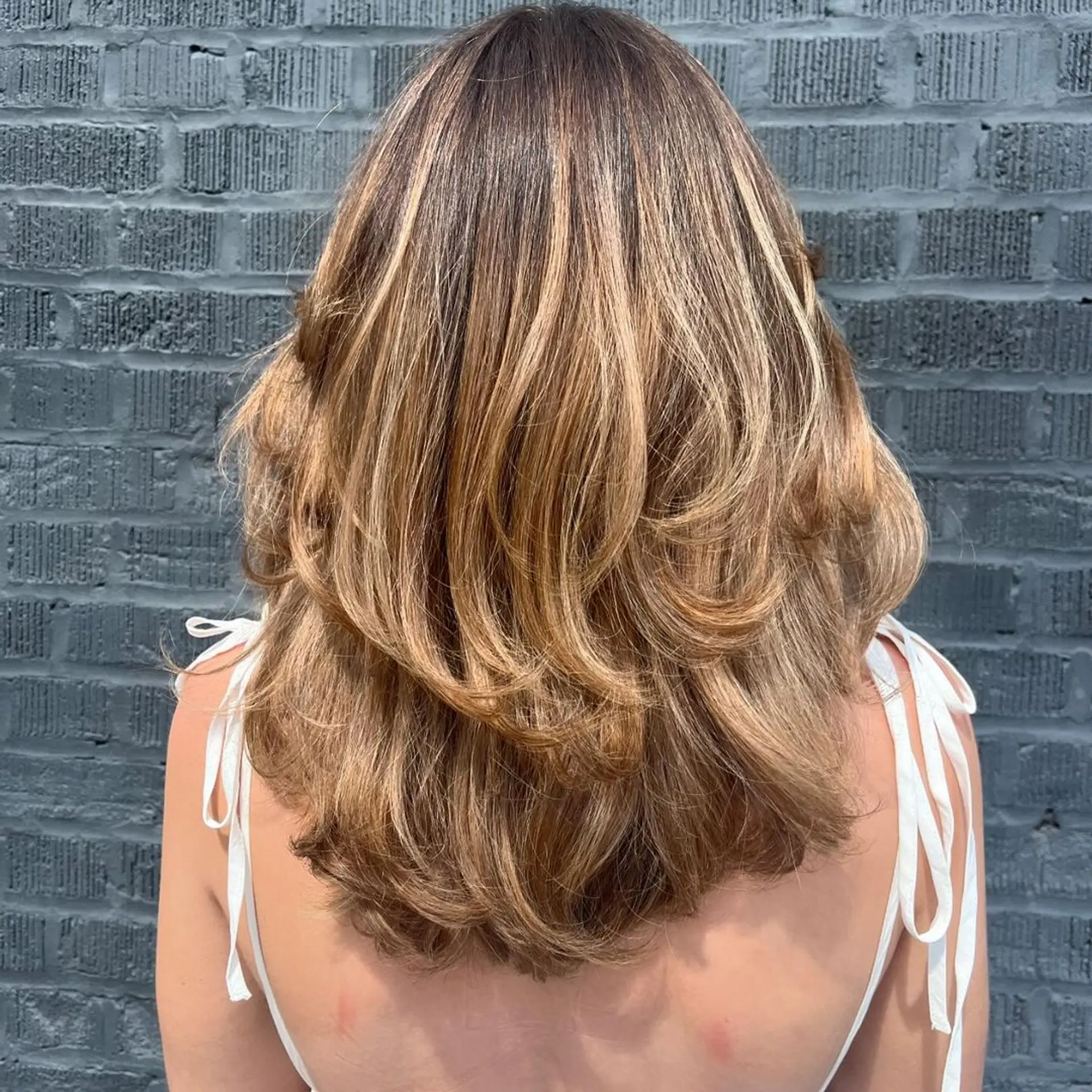 Medium length, honey blonde waves with feathered, face-framing layers and side-swept bangs.

versatile cut to have a beautiful shape both curly and straight ✨🌟💫 2