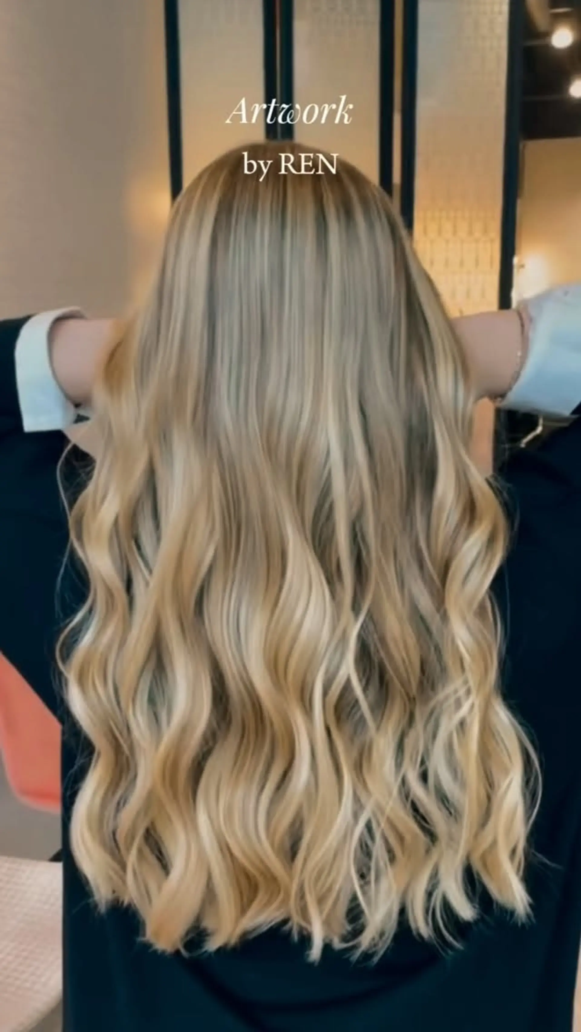 Long multi-tonal blonde hair styled into loose, flowing waves. 1