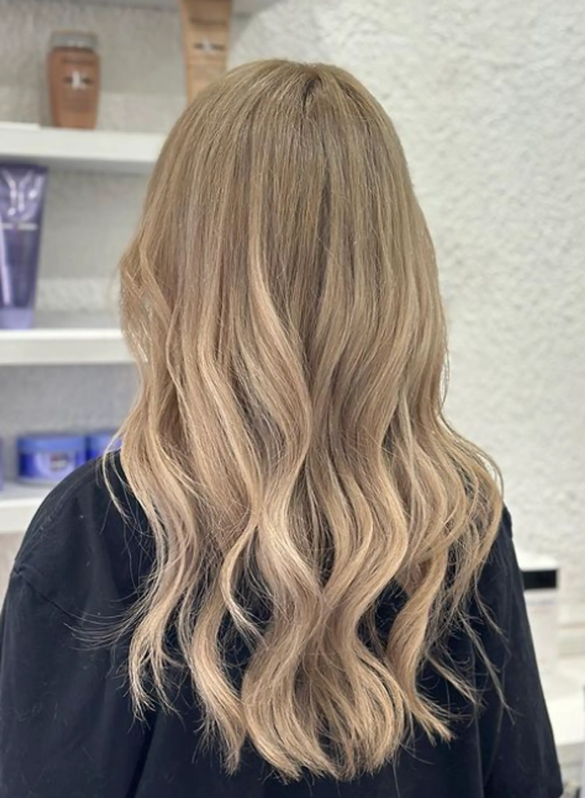 A long, wavy, golden blonde hairstyle with natural flow and subtle layering, creating an elegant and voluminous appearance. 1