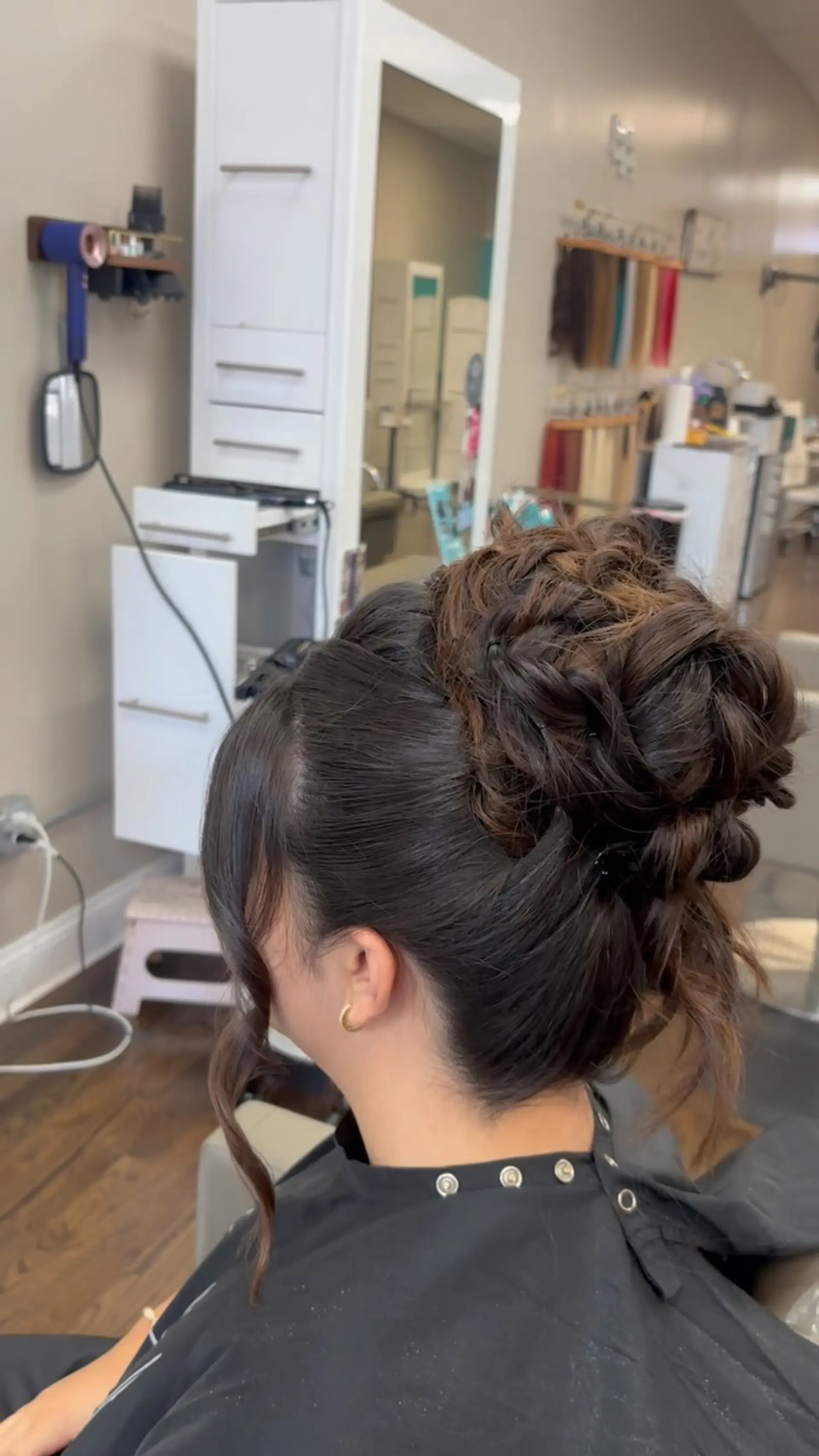 A sophisticated formal updo with woven, curled twists pinned high on the crown and soft face-framing tendrils. 1
