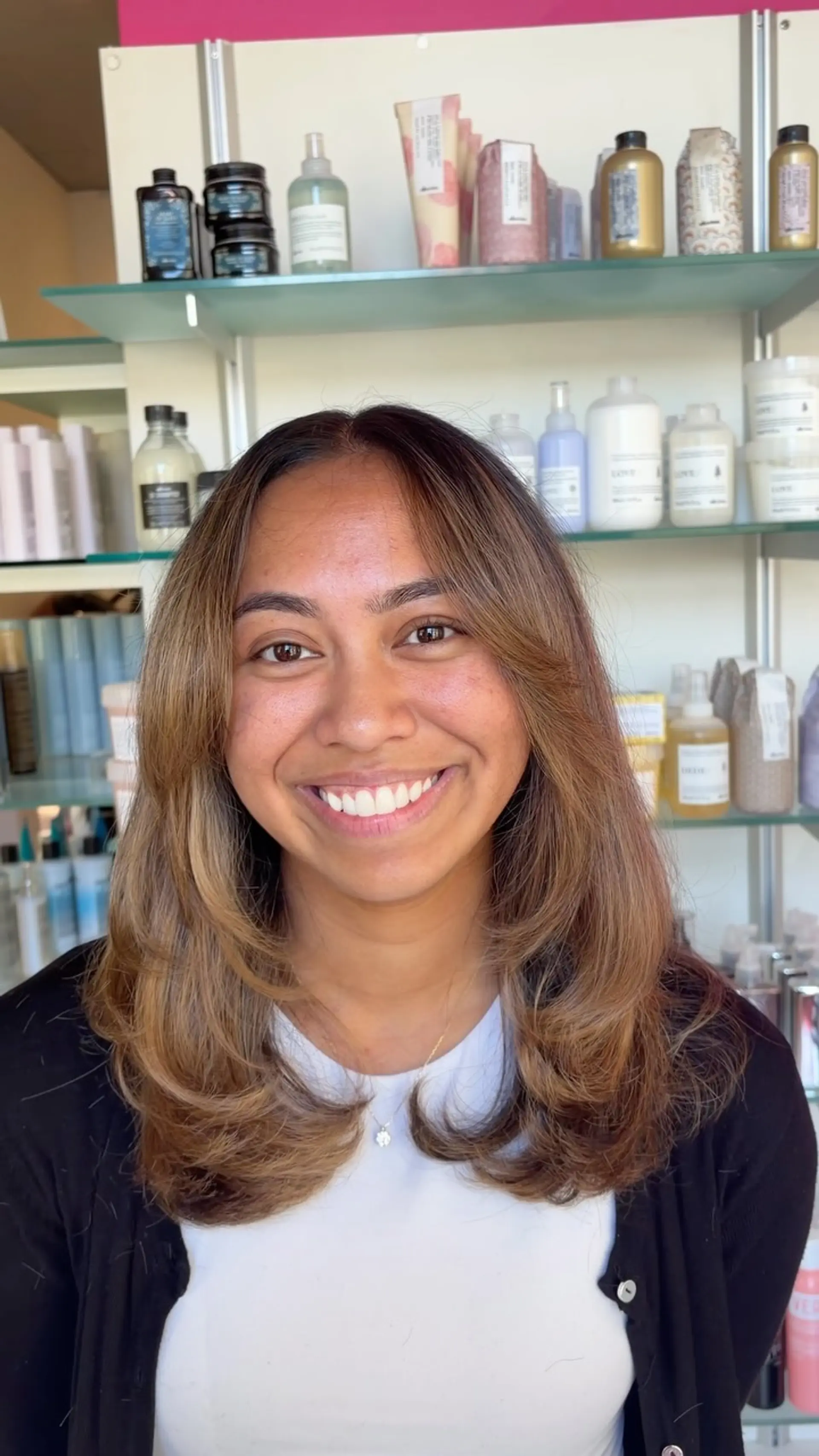 Medium-length layered haircut styled with a voluminous, inward-curling blowout and face-framing curtain layers. 1