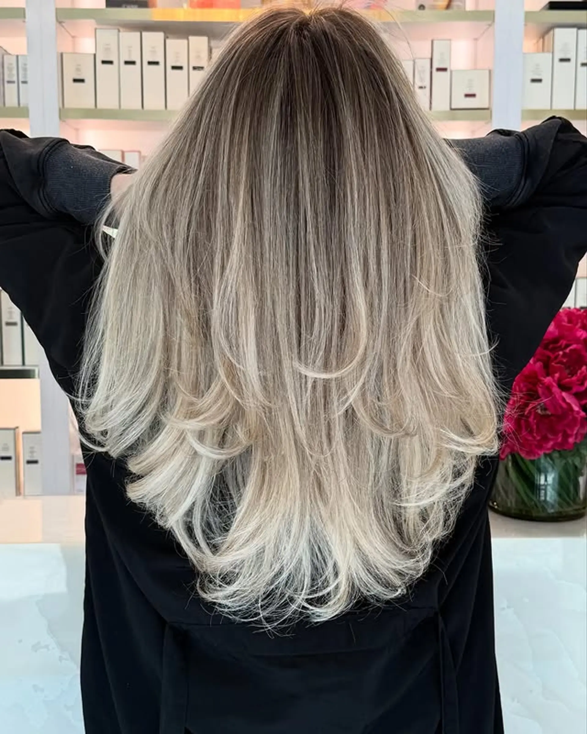 Long layered hairstyle with a seamless ash blonde balayage. 1