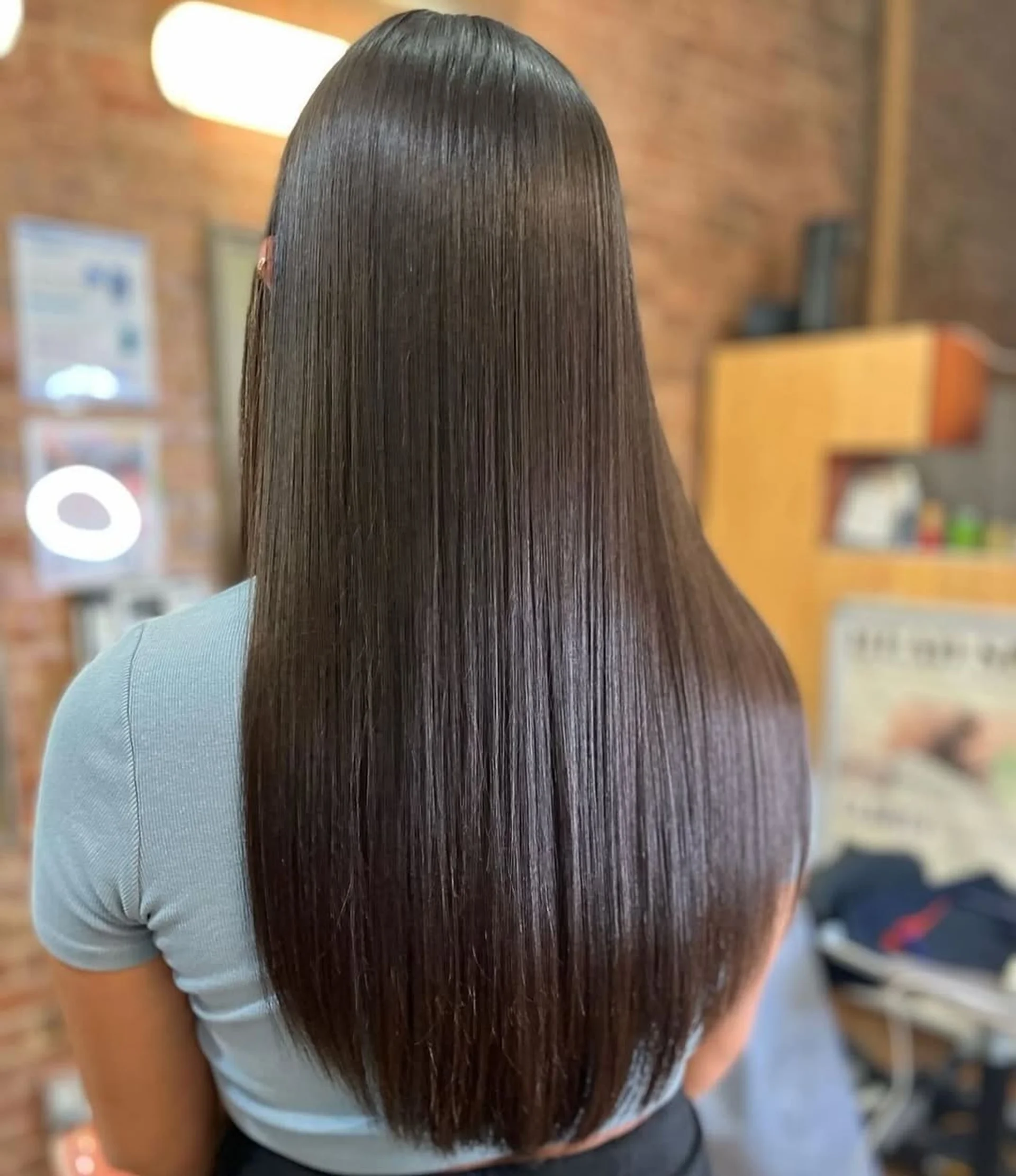 Woman with sleek, ultra-glossy long hair, embodying the 'glass hair' trend. - Preview 2