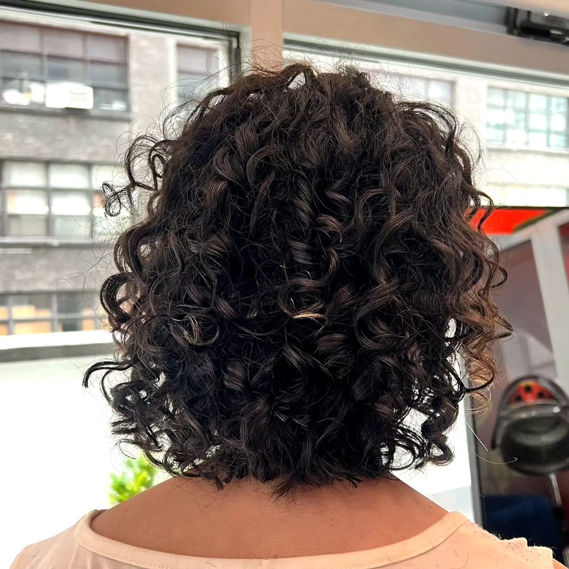 Medium-length, dark brown curls that are defined into neat, voluminous ringlets with a casual yet sophisticated look. 2