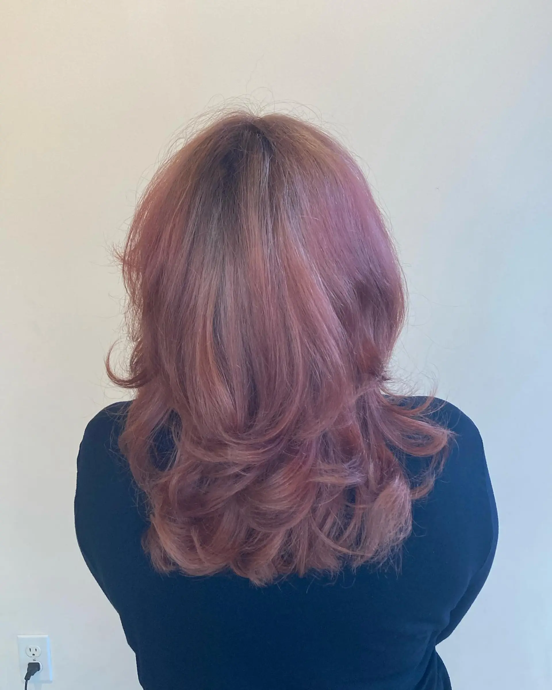 A medium-length shag haircut with soft, feathered layers and flipped ends in a cool-toned dusty red shade. 1
