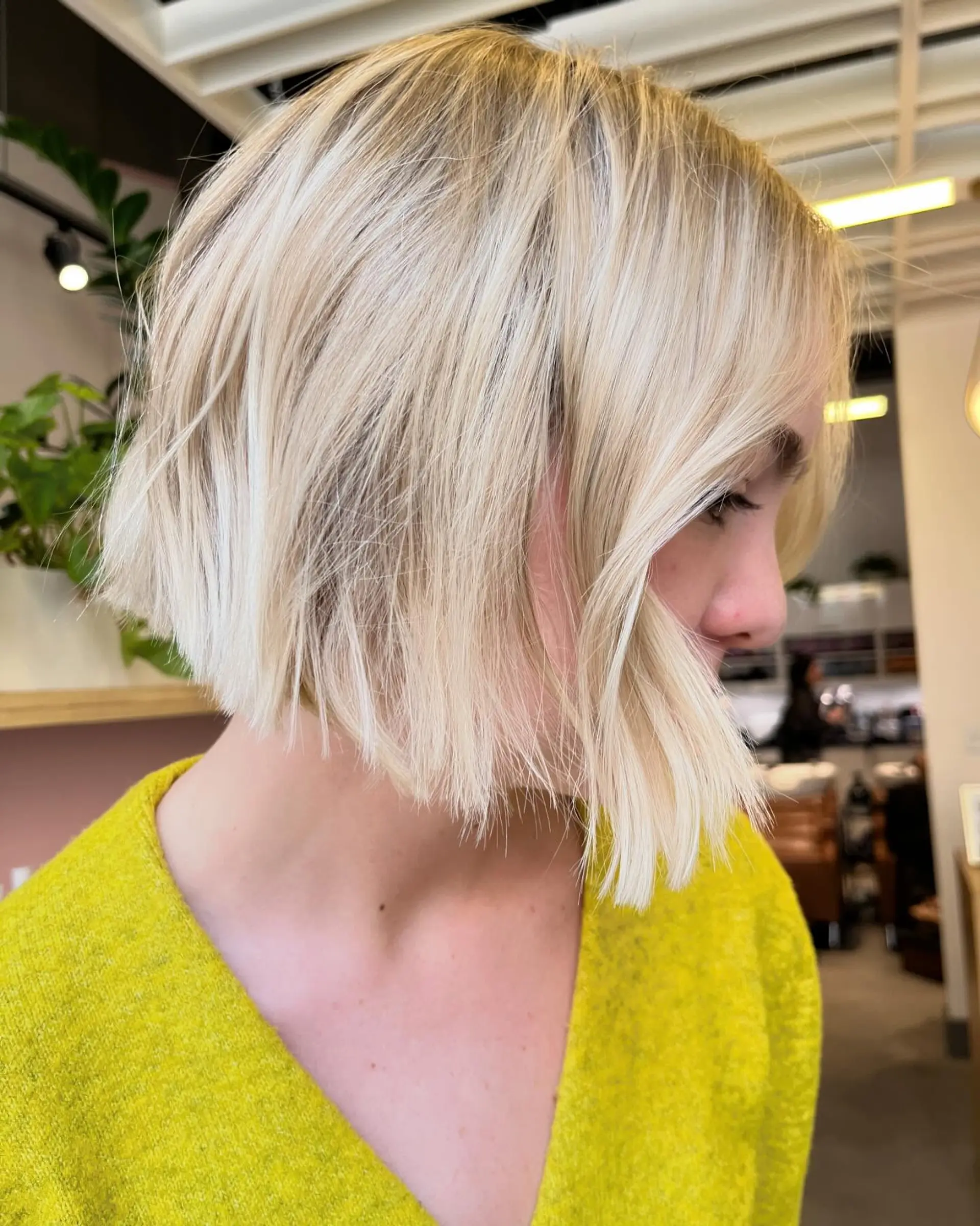 A textured jaw-length blonde bob cut with wispy, piecey ends and face-framing fringe. 1