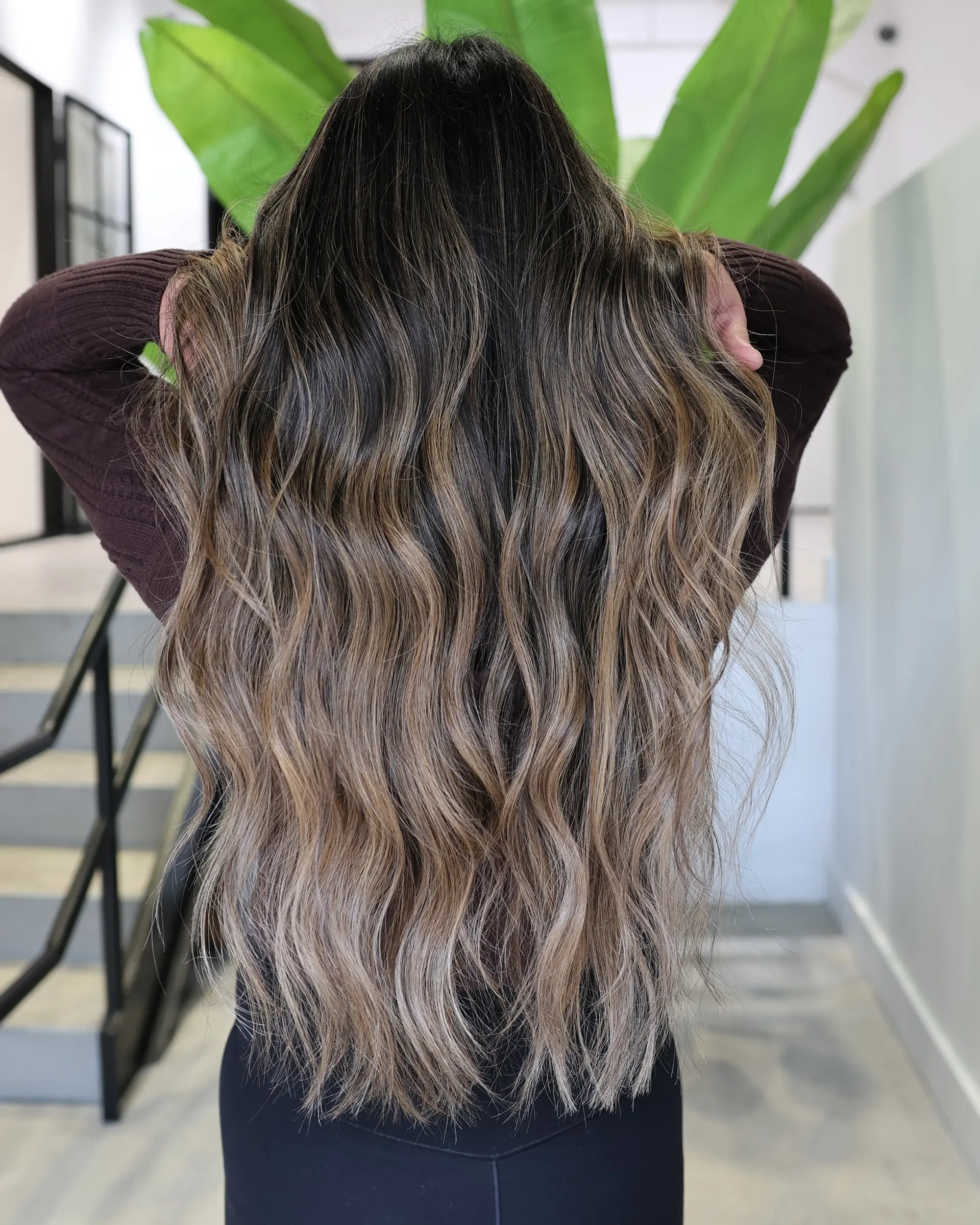 A long, wavy hairstyle with a beautiful balayage and face-framing curtain bangs. 4