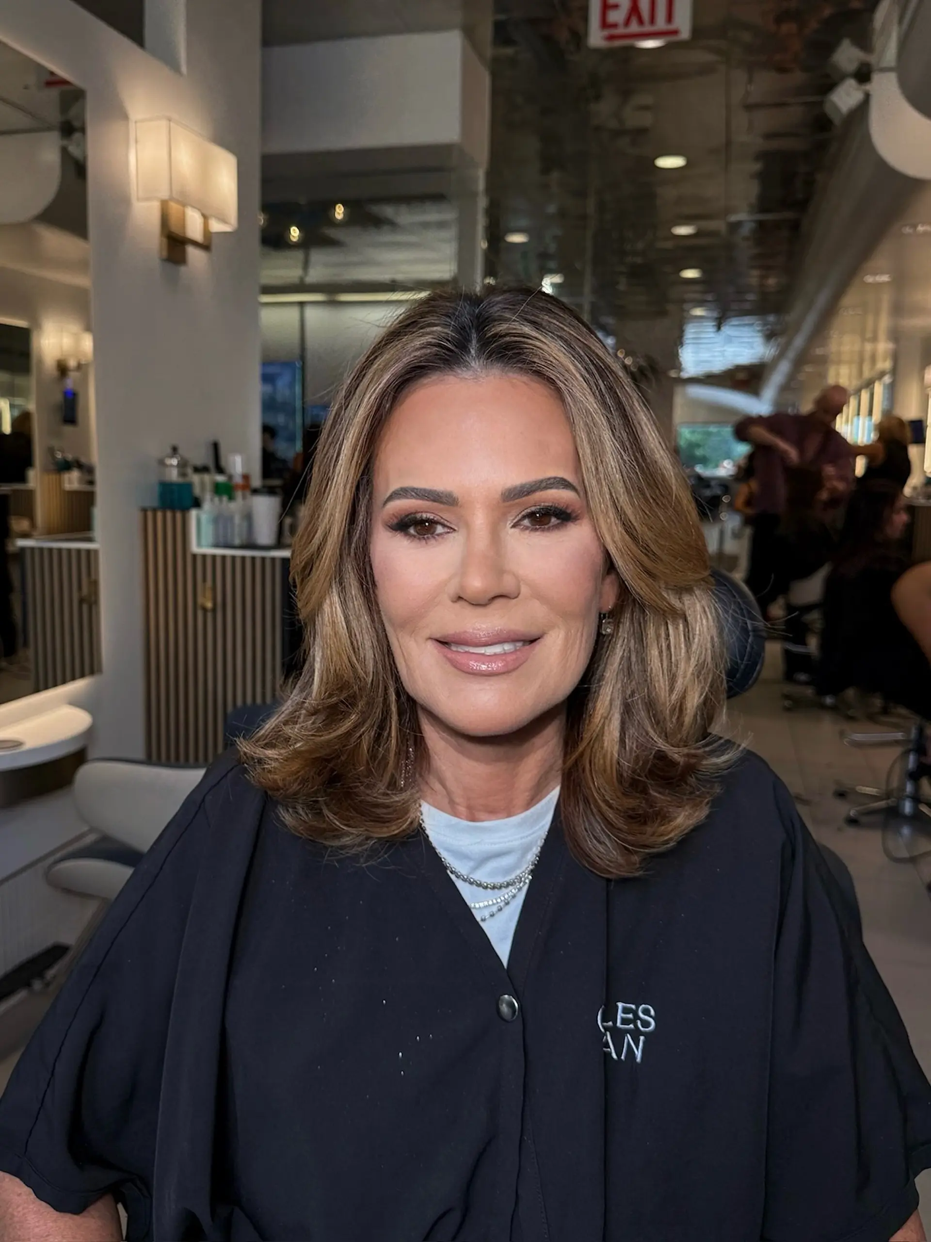 A polished shoulder-length blowout styled with face-framing layers, soft volume, and curled ends. 1