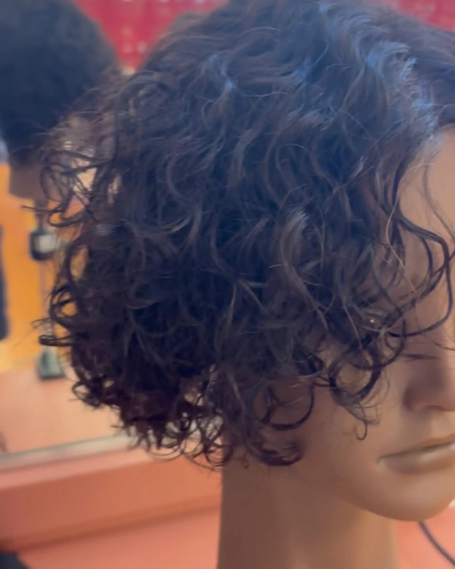 A layered short haircut styled with defined, tousled natural curls. 1