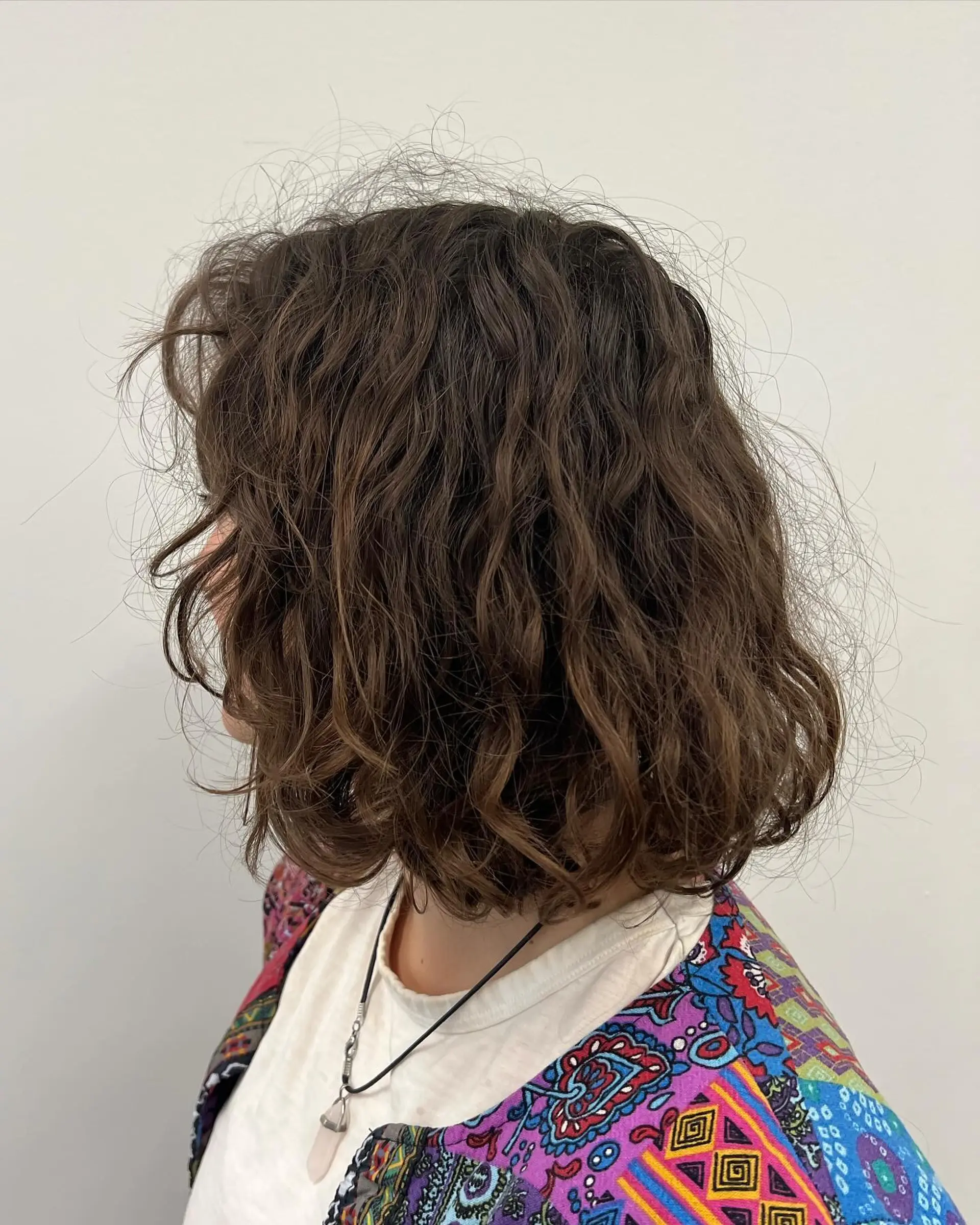 A neck-length textured bob cut featuring defined natural waves and a soft, tousled finish. 1