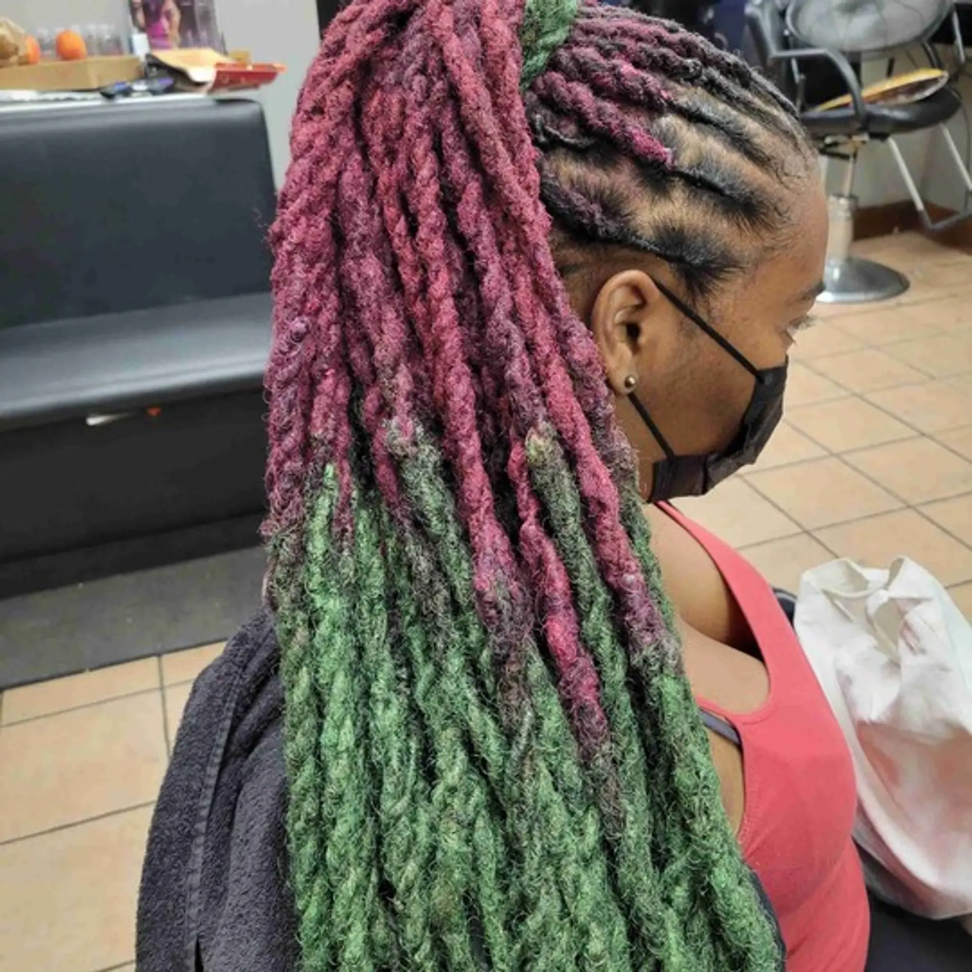 A two-toned faux locs hairstyle styled into a high ponytail with cornrow base. 1