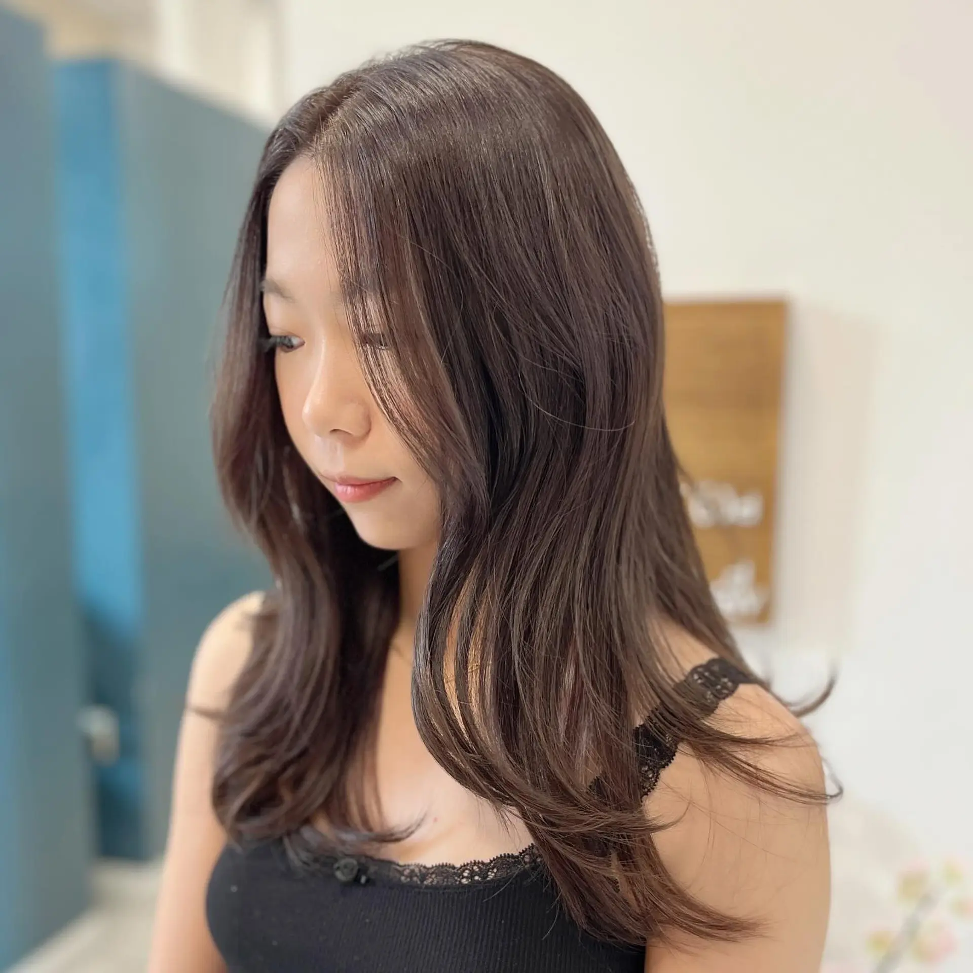 Long layered mocha brown hair with soft face-framing curtain bangs and gently curled ends. 1