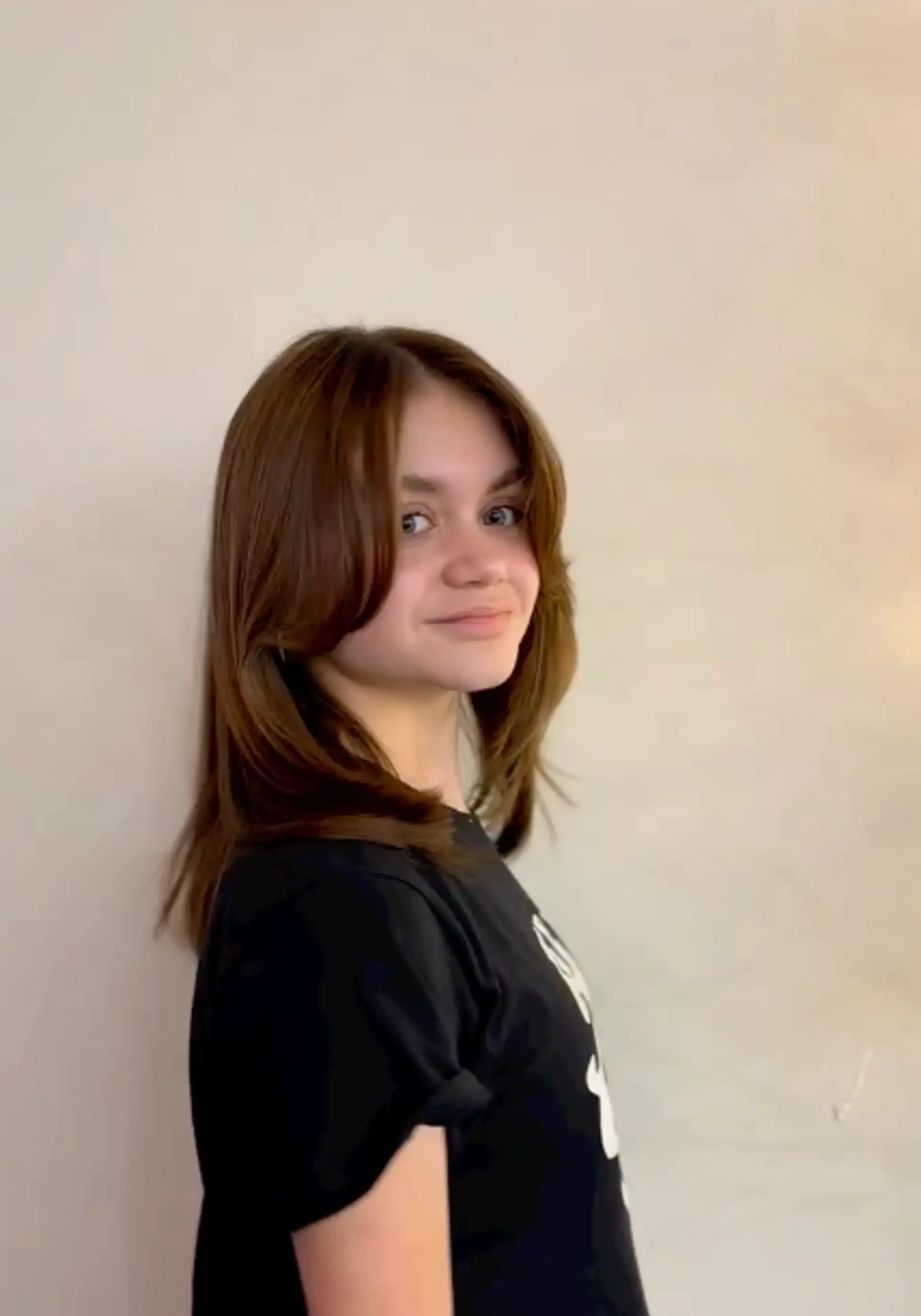 This hairstyle features curtain bangs and face-framing layers for a shaggy, trendy look. 1