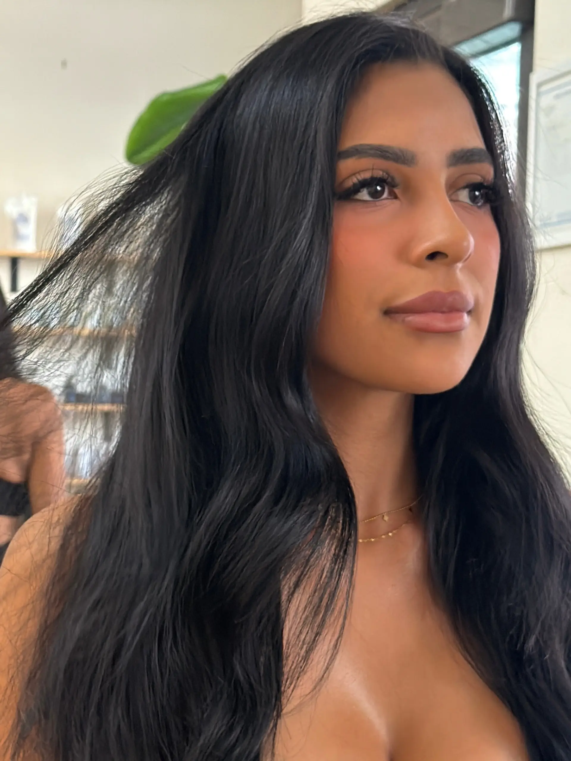 Voluminous long jet black hair styled with soft, touchable body waves and seamless blending. 1