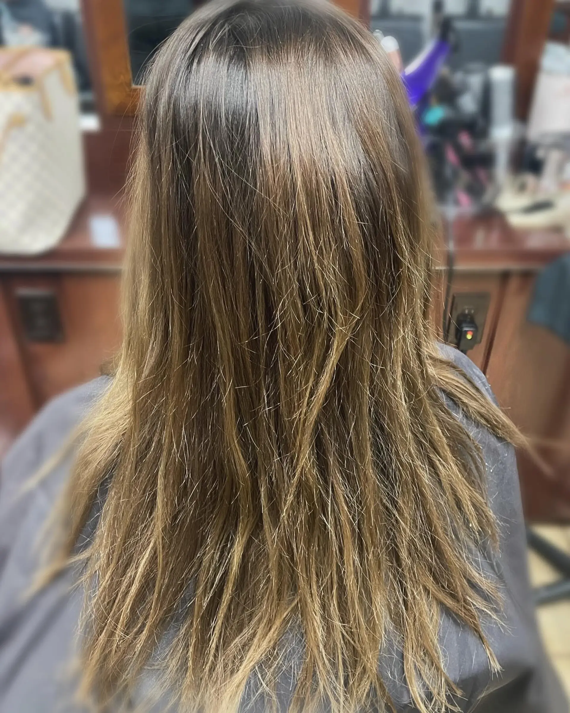 Long straight brunette hair detailed with fine, warm honey and light brown highlights for soft dimension. 1