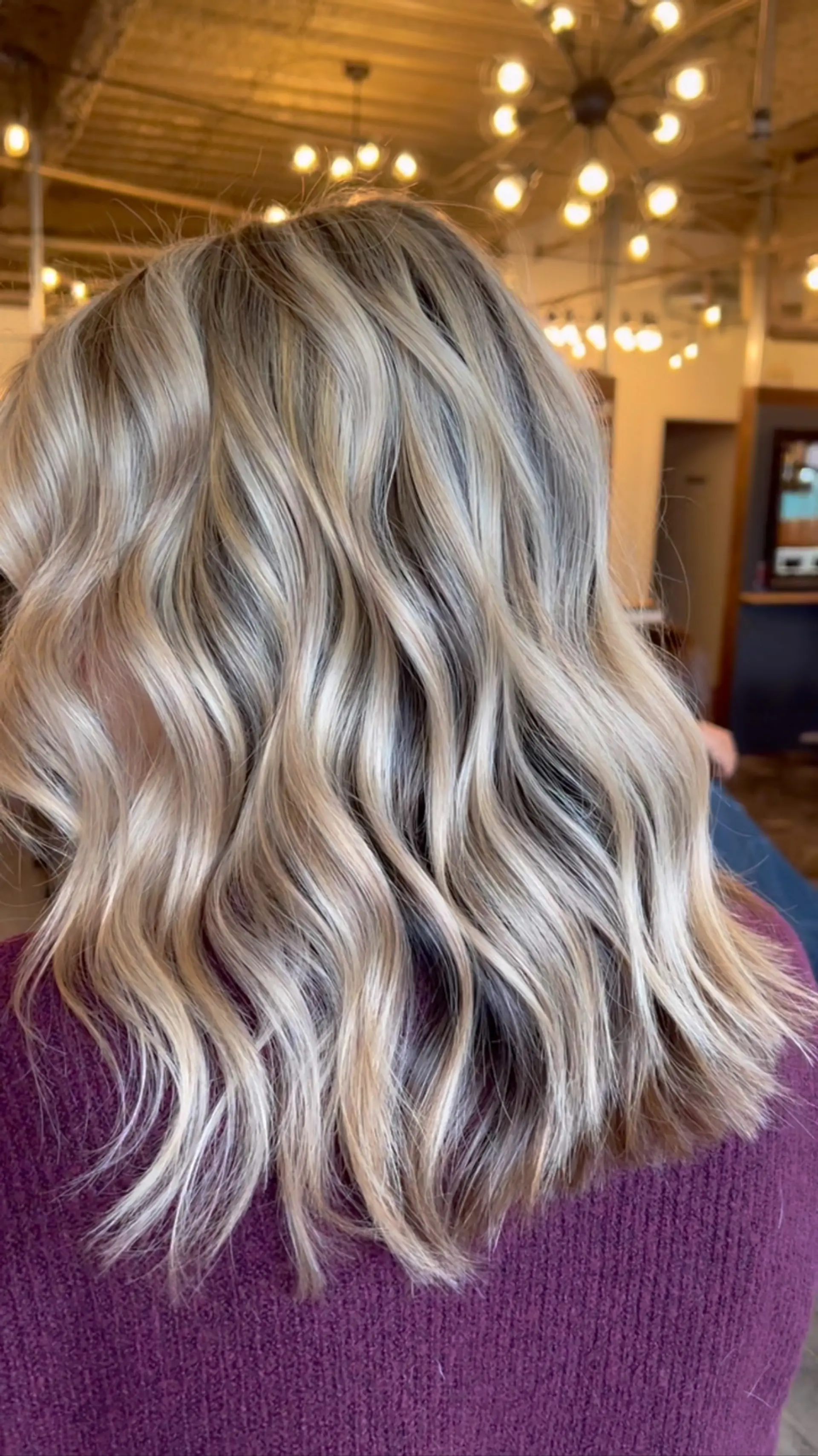 Medium-length dimensional blonde hair styled into glossy, loose waves. 1