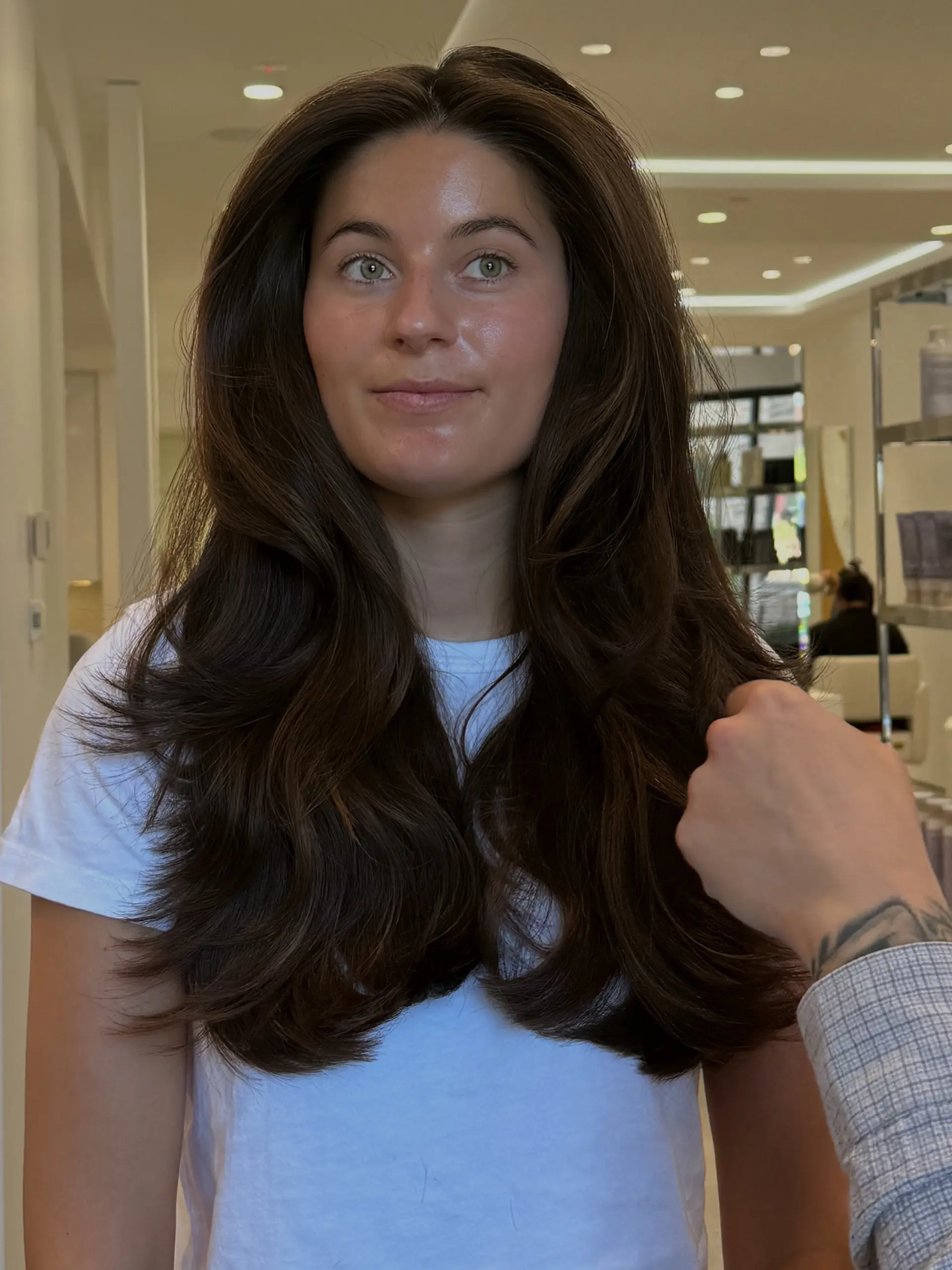 Long, thick dark brown hair cut with soft face-framing layers and styled with a voluminous blowout. 1