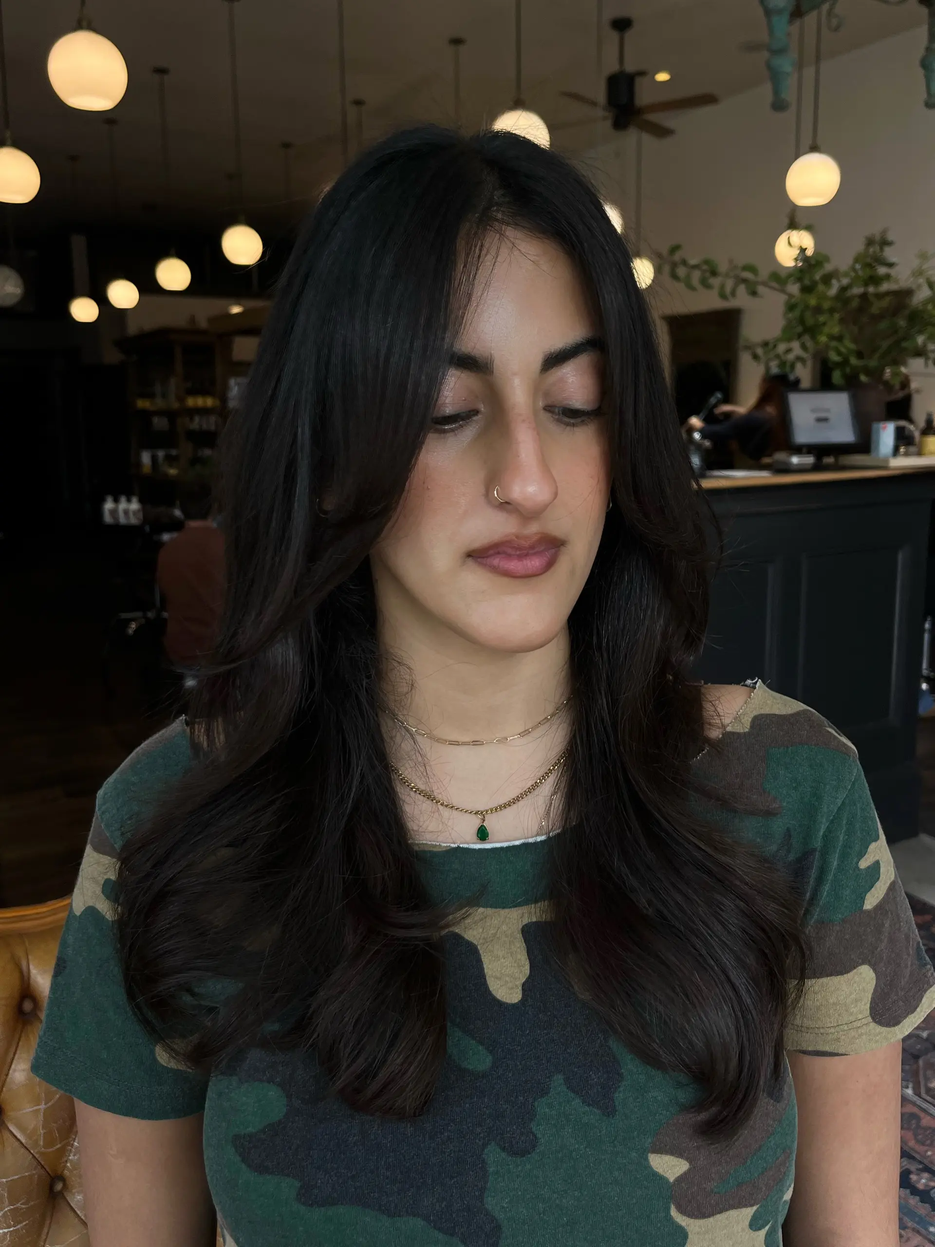 Long, rich dark brown hair styled with cascading layers, soft face-framing fringe, and a voluminous, bouncy blowout finish. 1