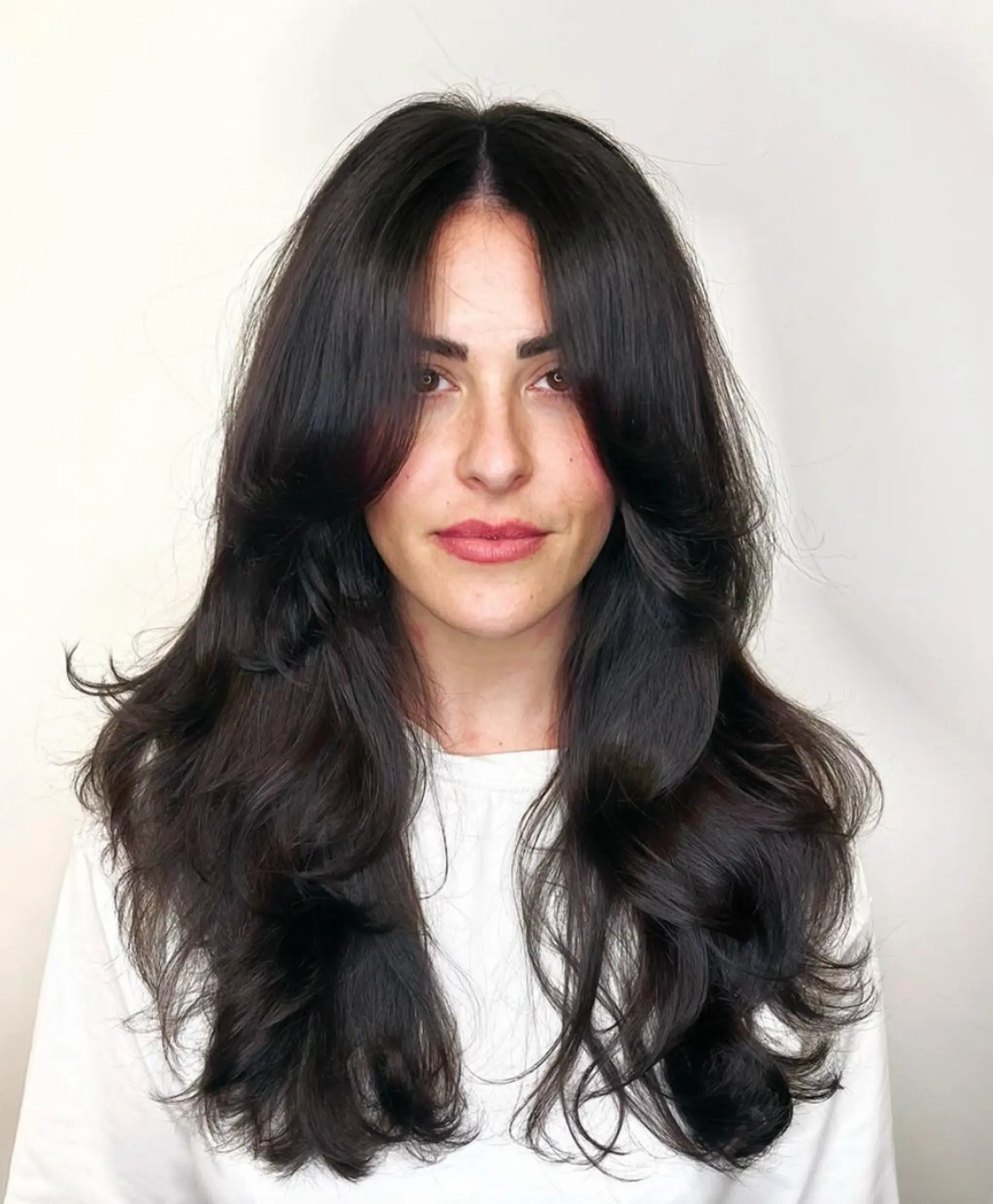 Long, wavy dark brown to black hair with curtain bangs and face-framing layers, finished with a glossy shine.

Cut and style by @juliamannino_hair
Gloss by @simabeautynyc


 1