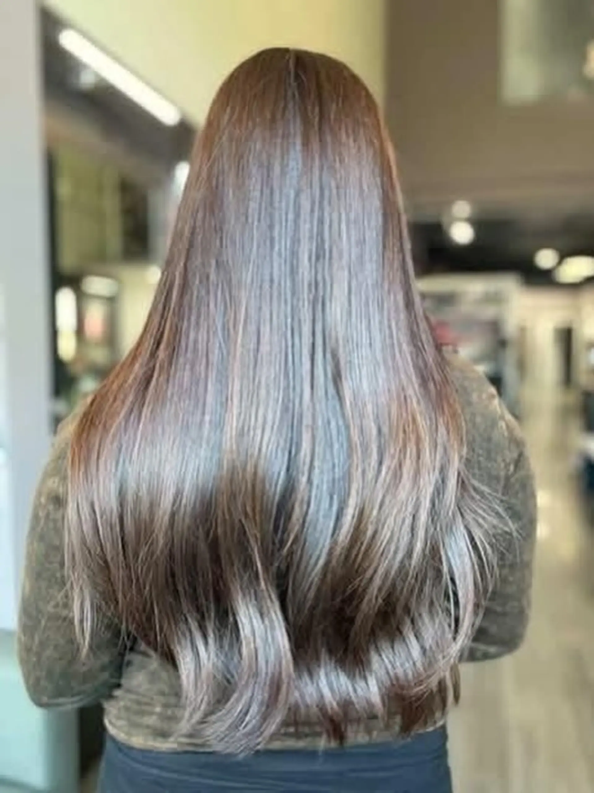 Extra long, glossy chocolate brown hair featuring subtle caramel ribbons, styled sleek with soft curved ends. 1