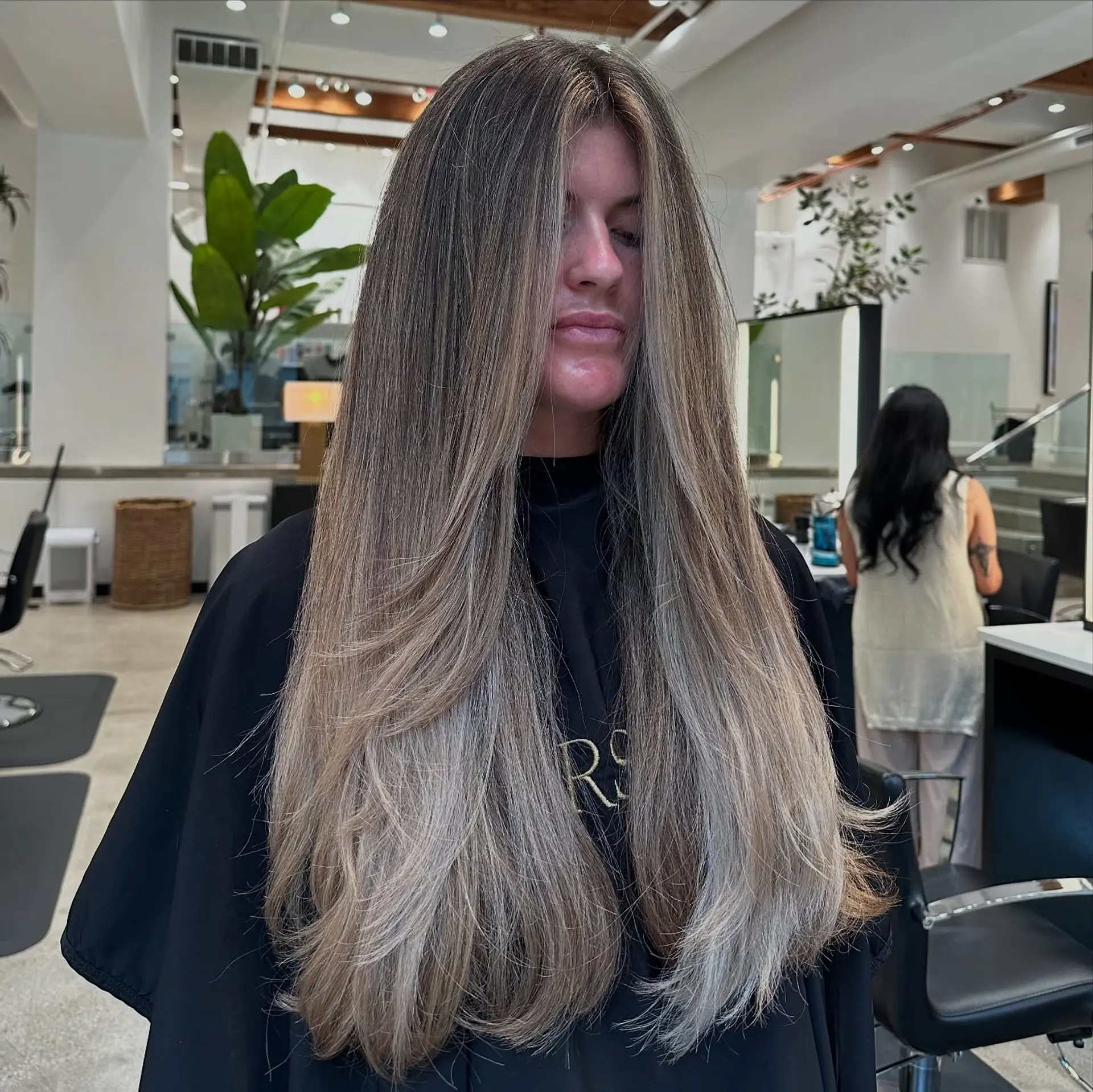 Long layered hairstyle with an ash blonde balayage. 1