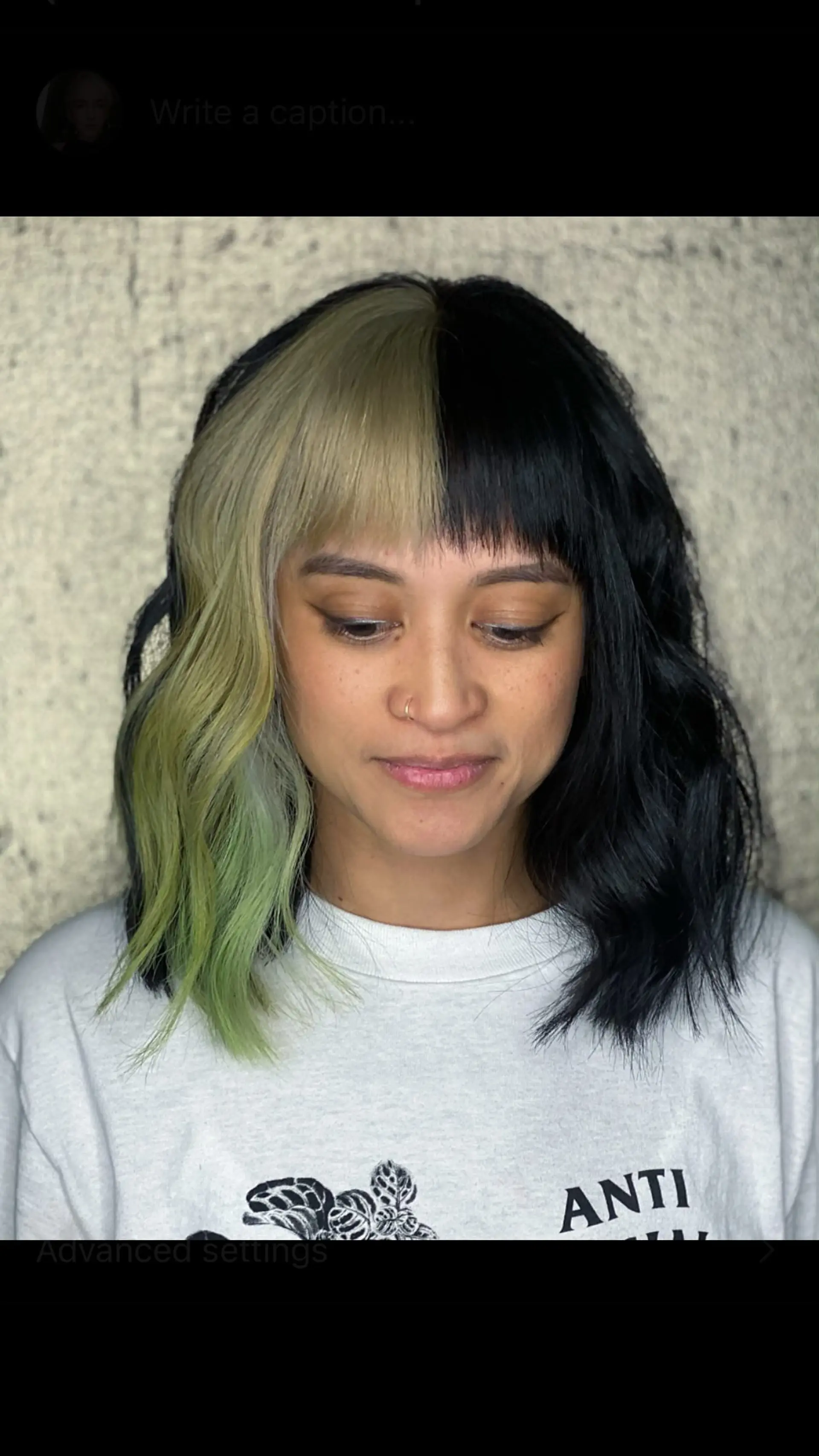 A split-color shoulder-length lob featuring blunt fringe bangs, with deep black on one half and pale blonde fading into mint green on the other. 1
