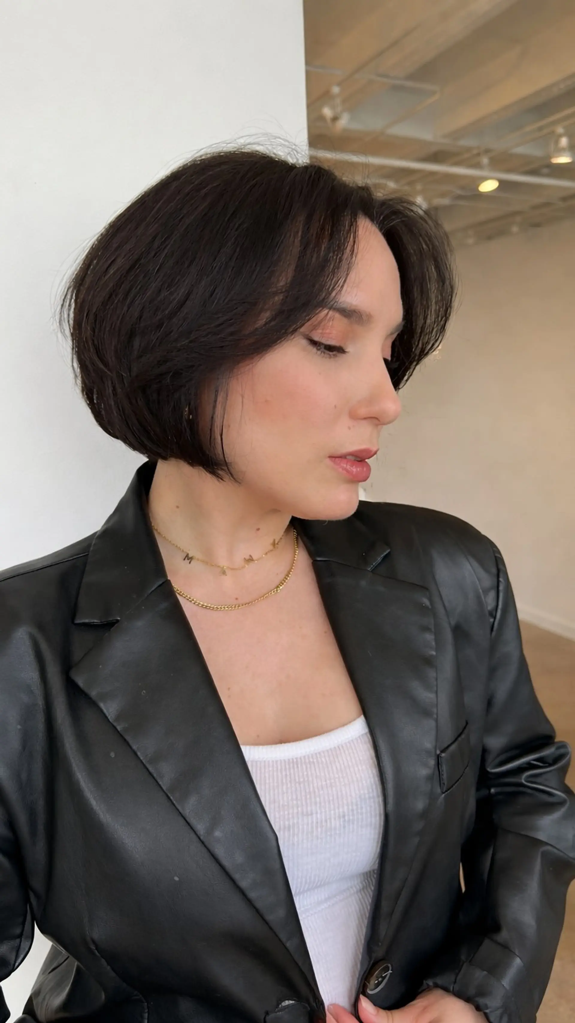 A sophisticated chin-length French bob featuring subtle textured layering, rounded volume, and soft wispy bangs framing the face. 1
