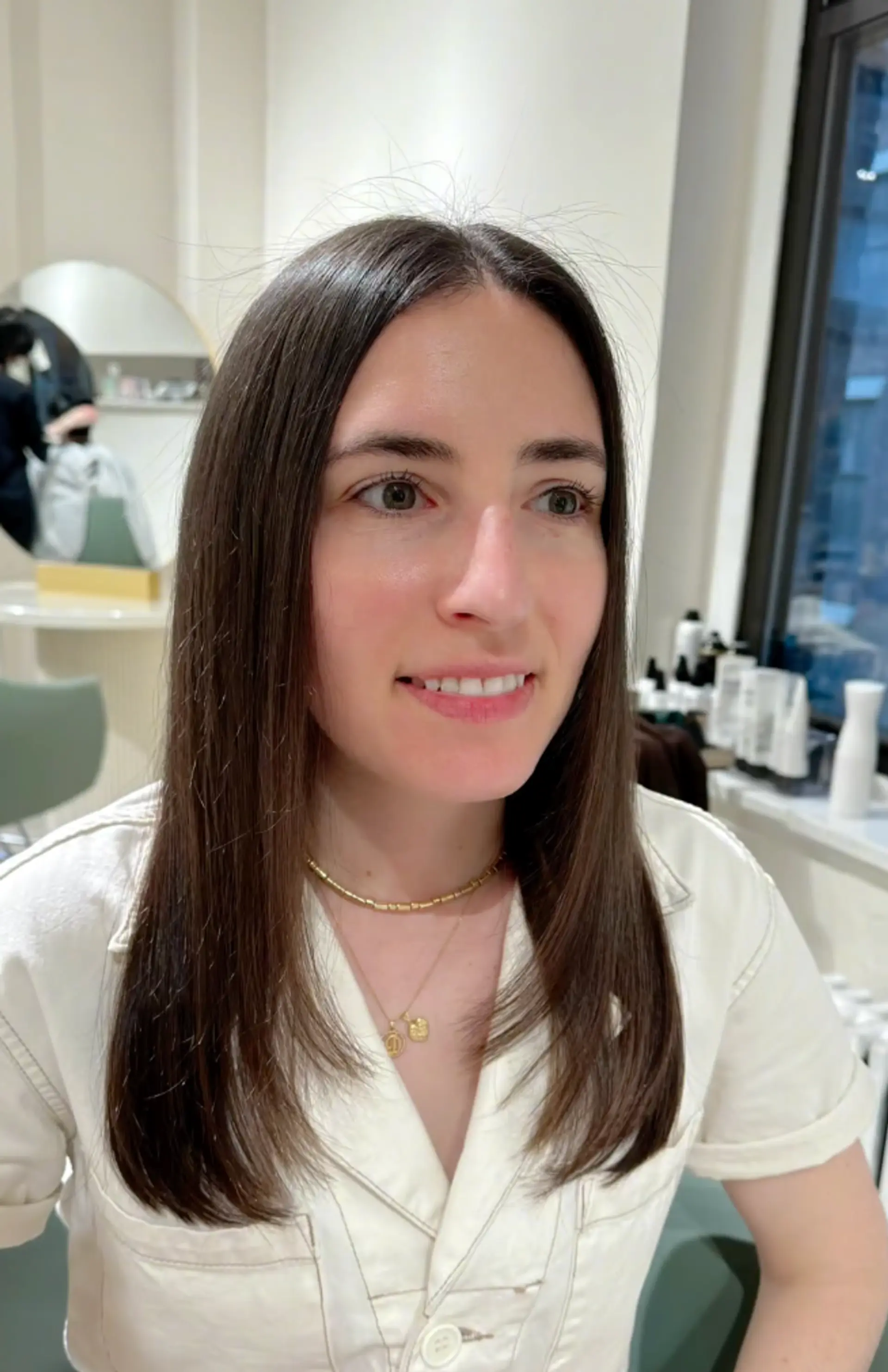 A medium-length, straight, dark brown hairstyle with a center part and minimal layering, boasting a sleek and polished finish with a healthy shine. 1