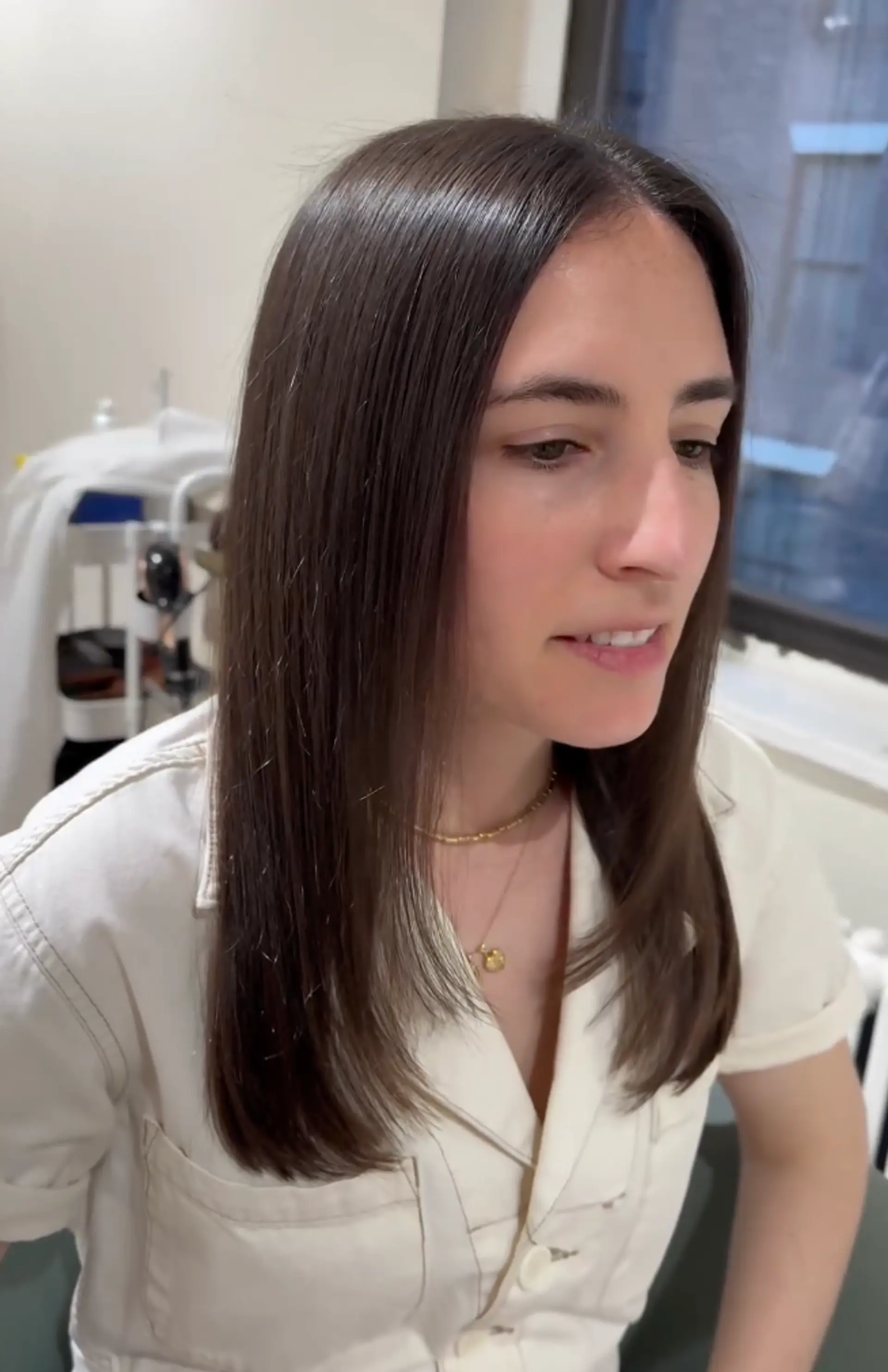 A medium-length, straight, dark brown hairstyle with a center part and minimal layering, boasting a sleek and polished finish with a healthy shine. 2