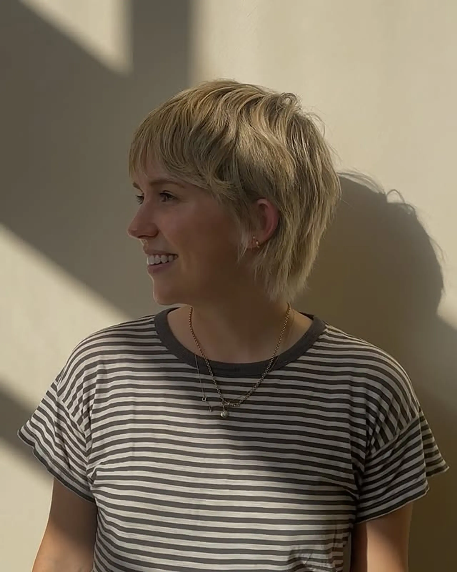 A short, shaggy pixie cut with textured bangs and choppy layers. 1