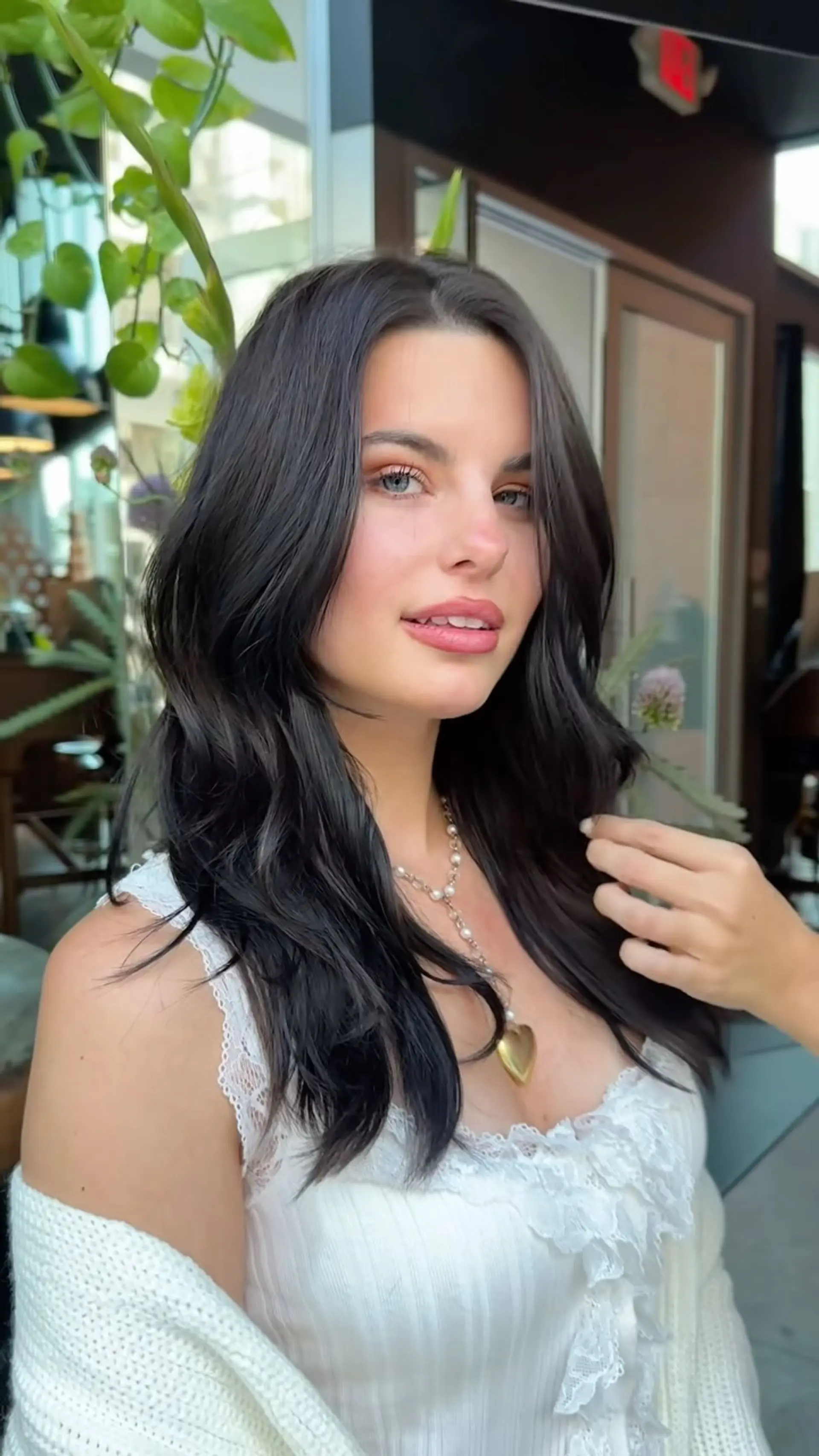 Long, rich dark hair styled with soft, voluminous waves and face-framing layers. 1