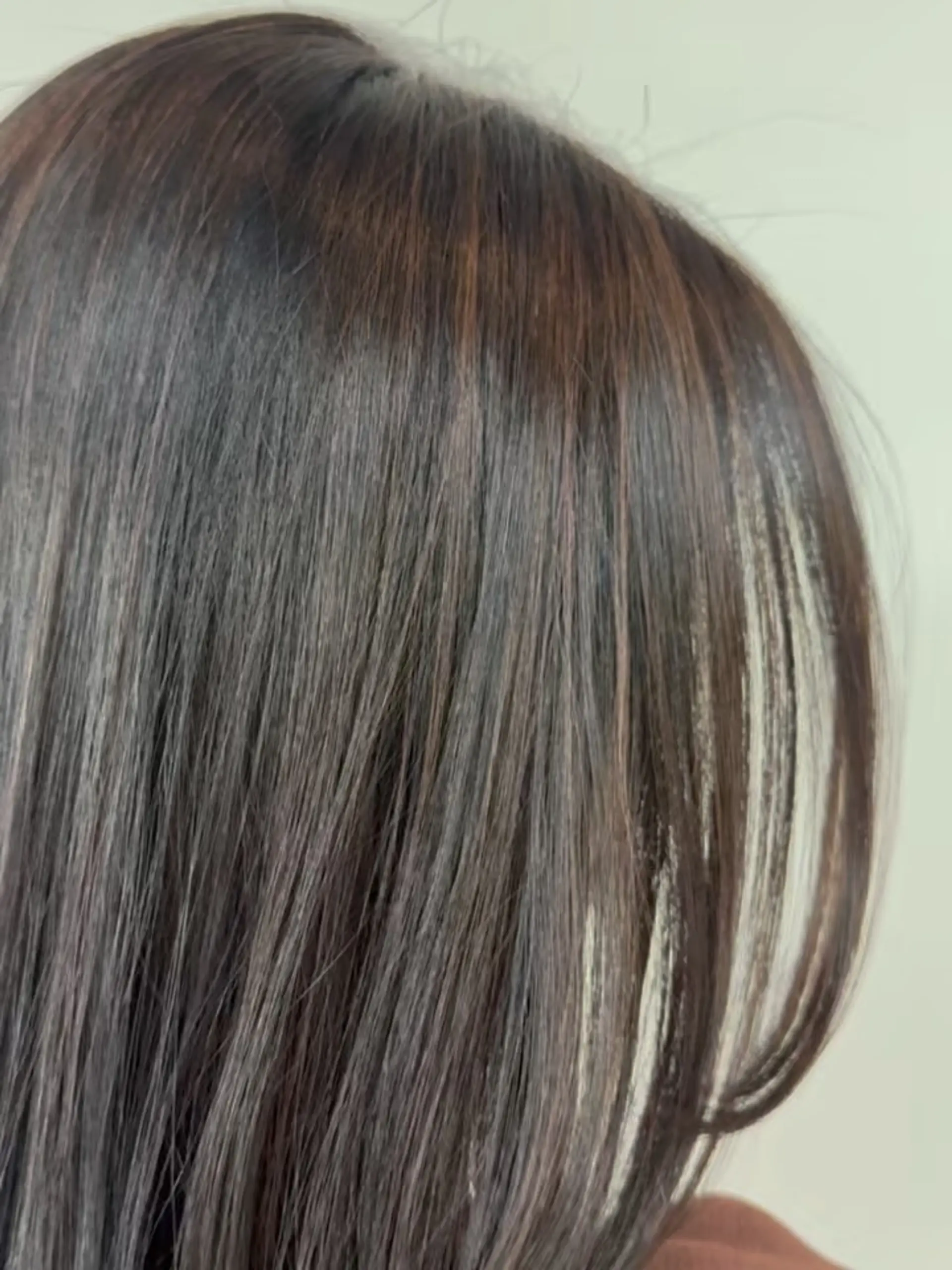 Subtle, blended sun-kissed highlights woven through straight dark brunette hair. 1
