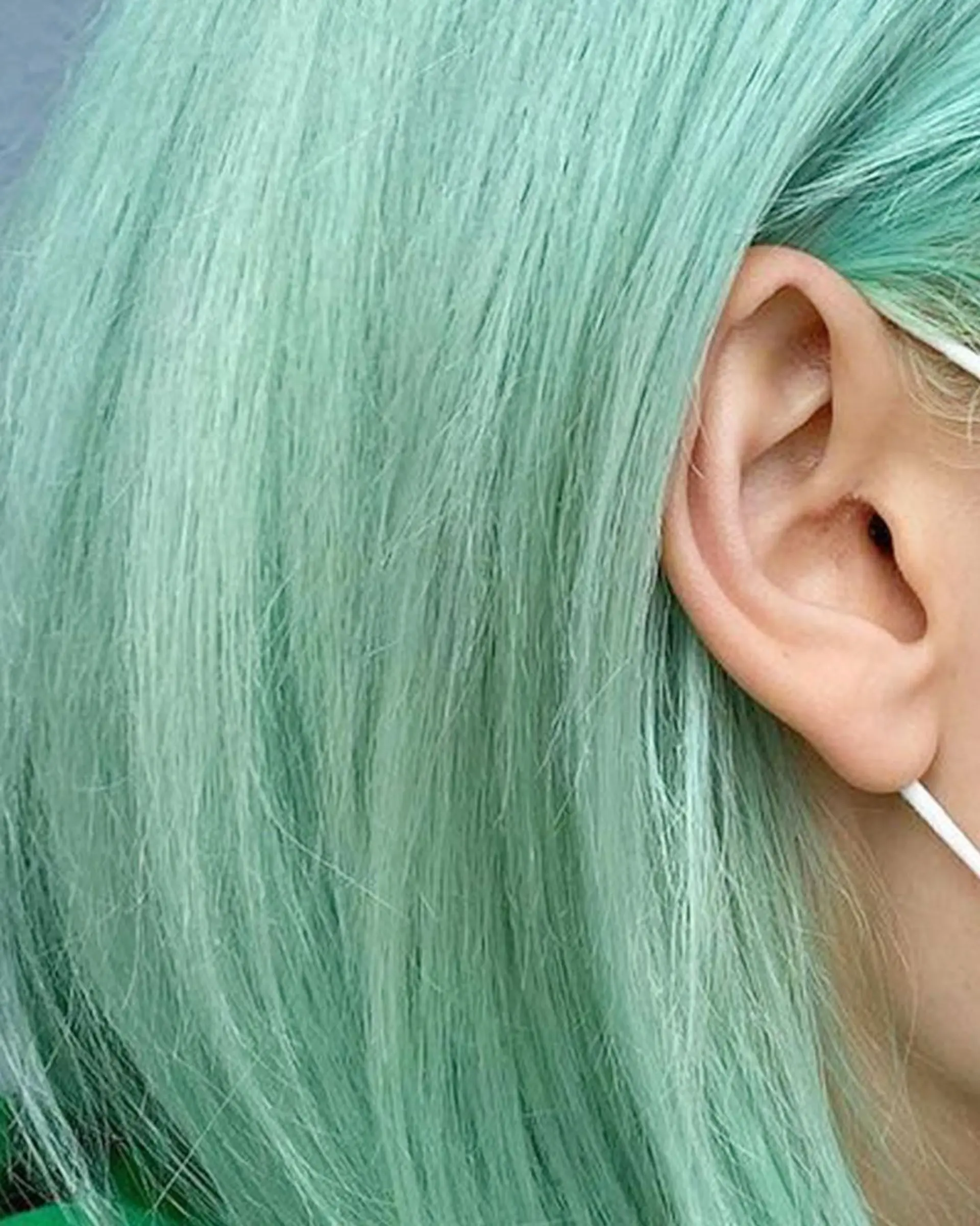 A chic, straight bob cut dyed in pastel mint green, offering a sleek and modern look. 2