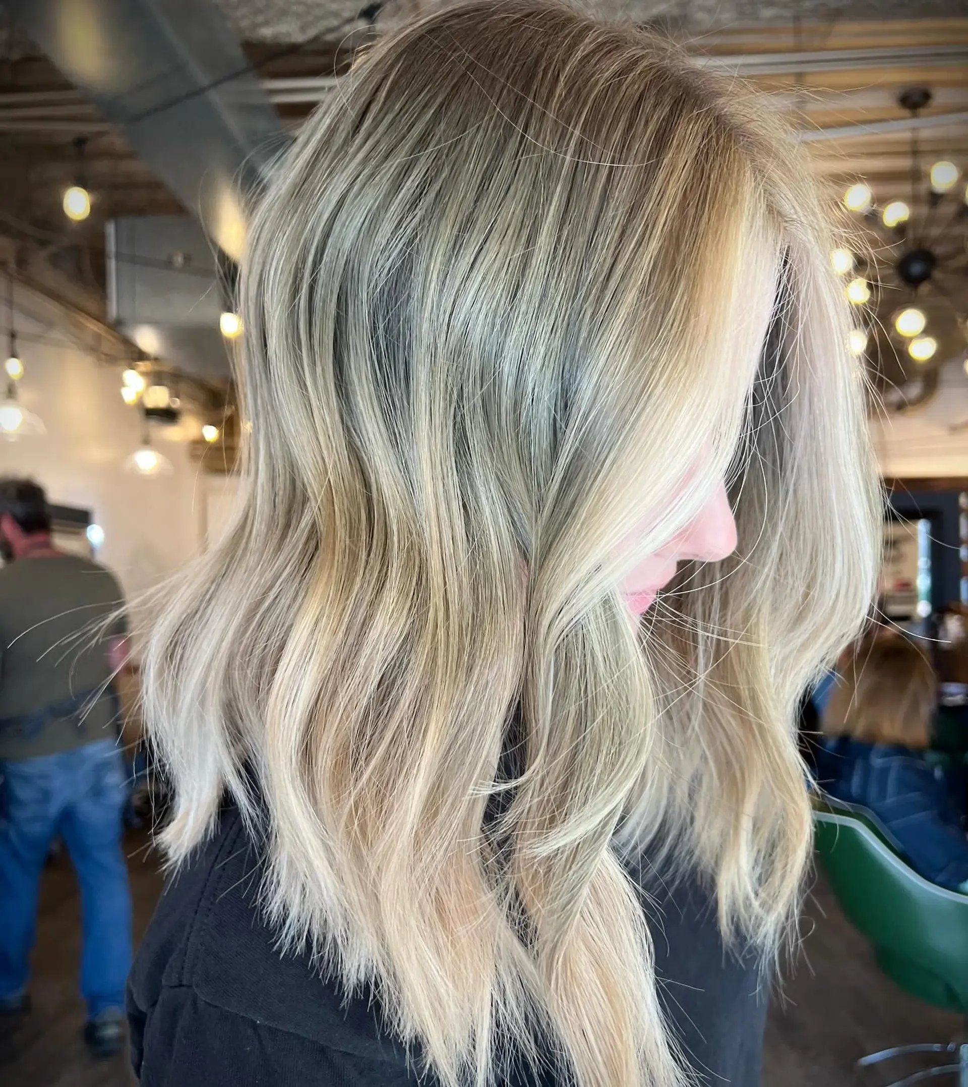 Shoulder-length textured lob styled in soft, undone waves with dimensional blonde highlights. 1