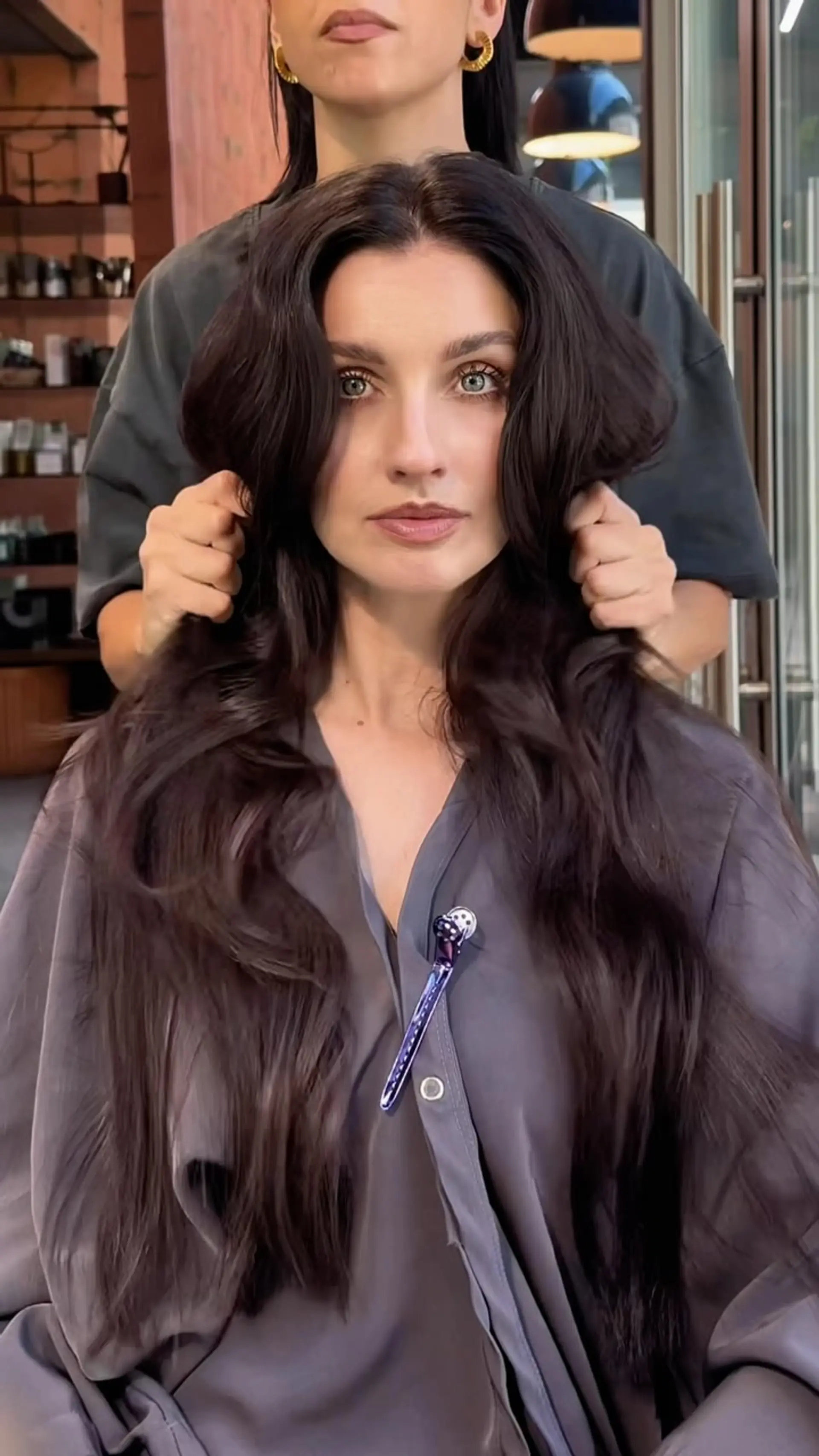 Long, voluminous dark brunette hair styled with soft, cascading waves and face-framing layers. 1