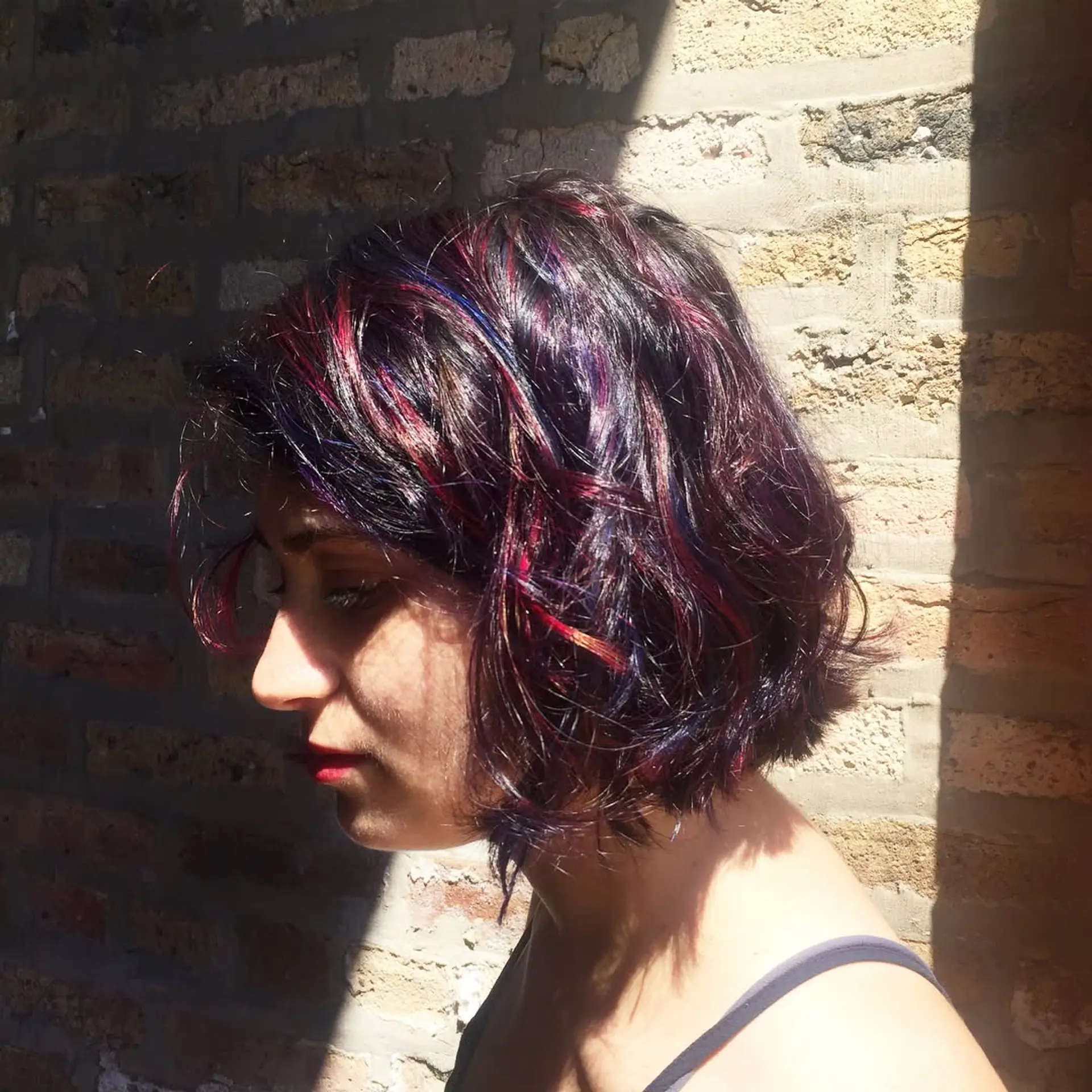 A chic, short wavy bob with layered highlights in bold jewel tones. 2