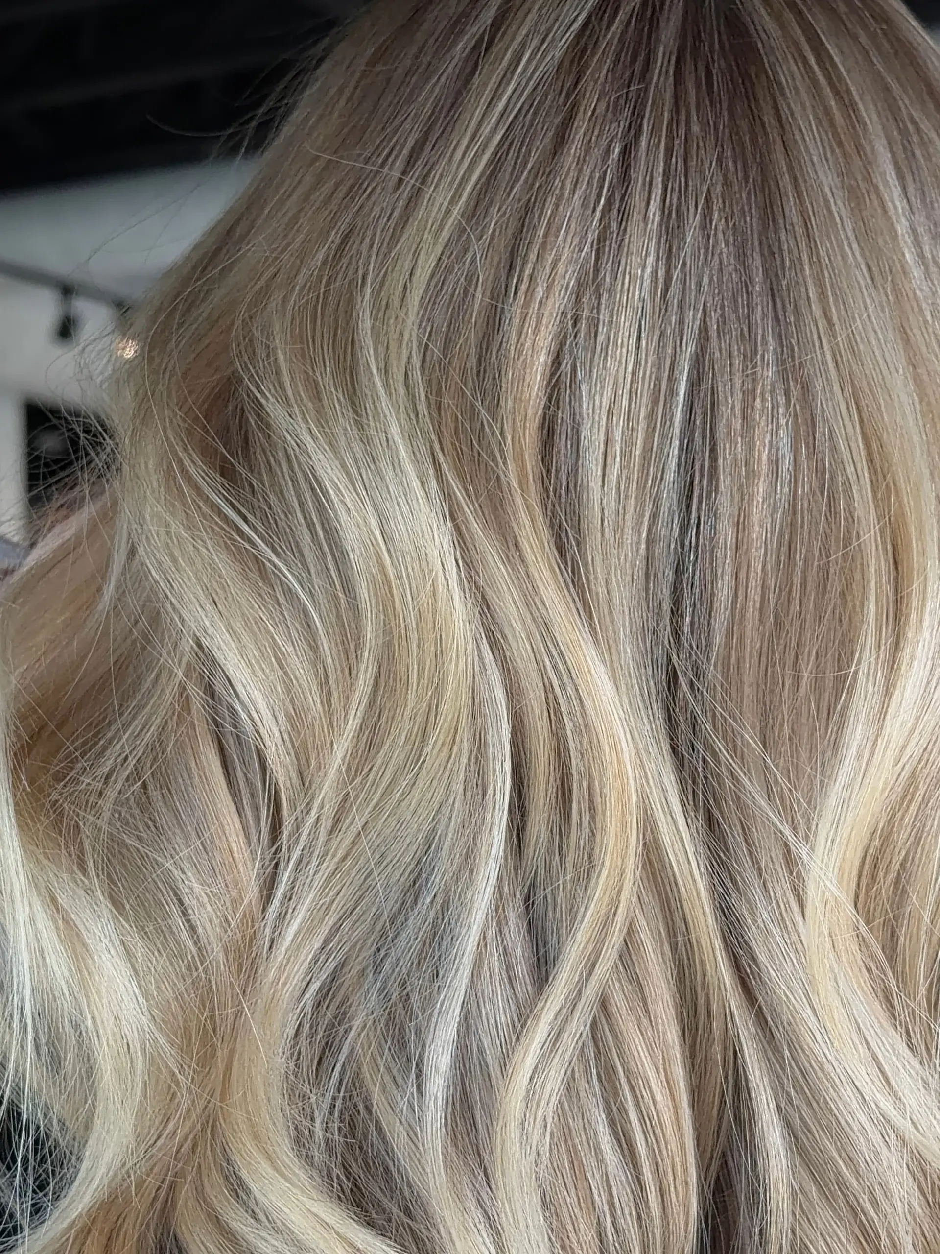 Multi-tonal blonde highlights blended throughout and styled with loose, soft waves. 1