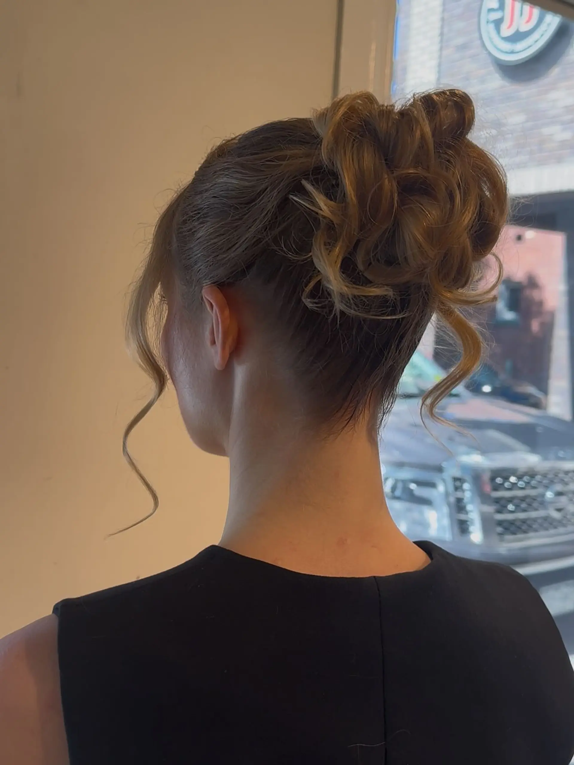 A romantic textured high updo with tousled curls and soft face-framing tendrils. 1
