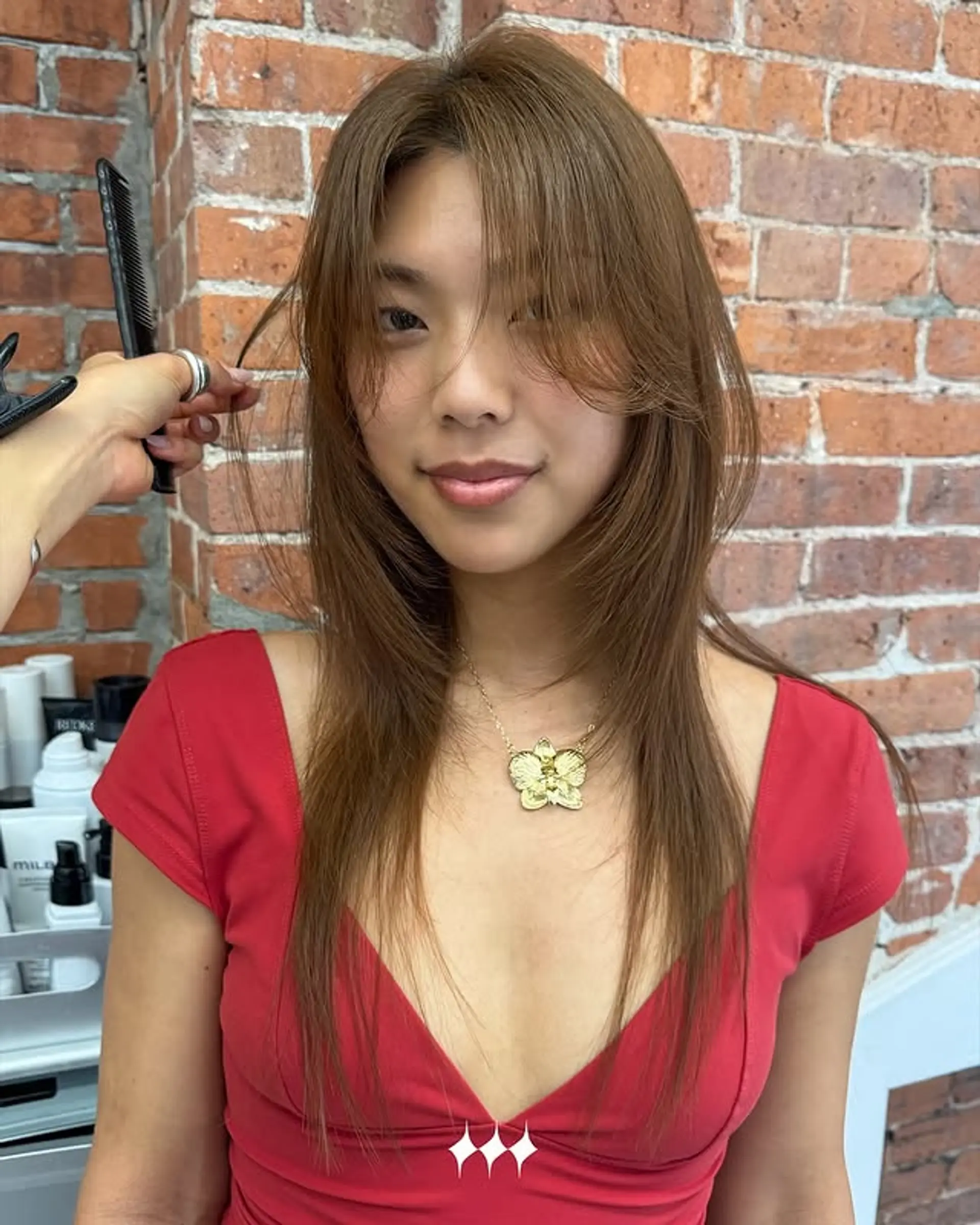 A medium-length layered cut with soft curtain bangs that frame the face. 1