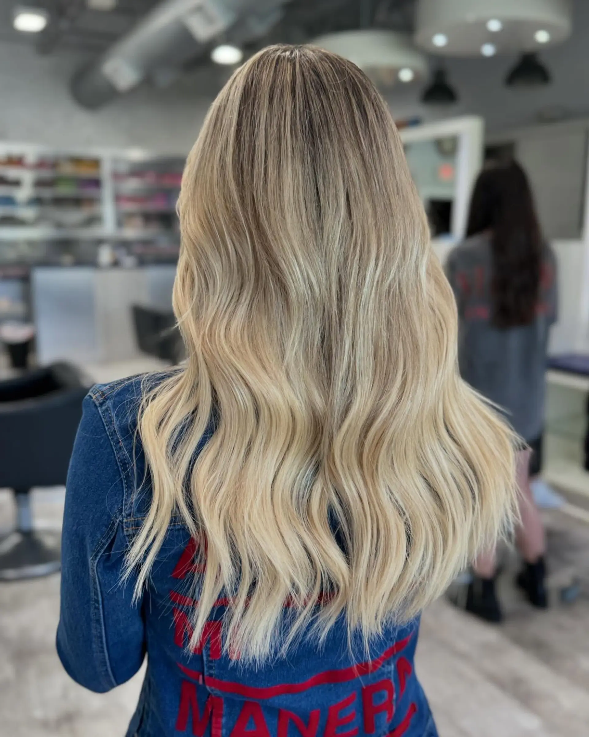 Long, wavy hair with a buttery blonde balayage and natural roots. 2